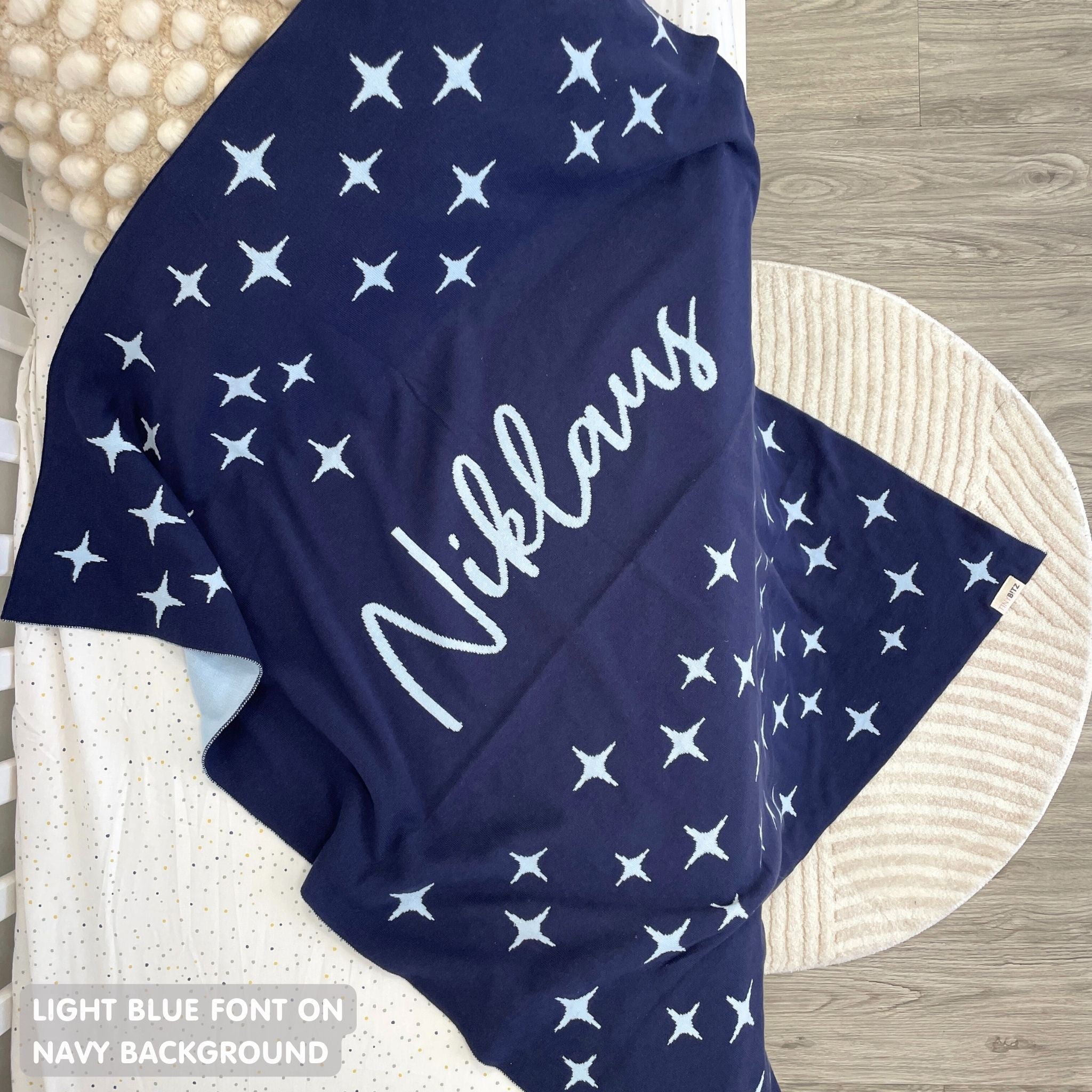 Knitted baby blanket in navy and light blue with a twinkles pattern, customised with baby's name, made by TinyBitz.