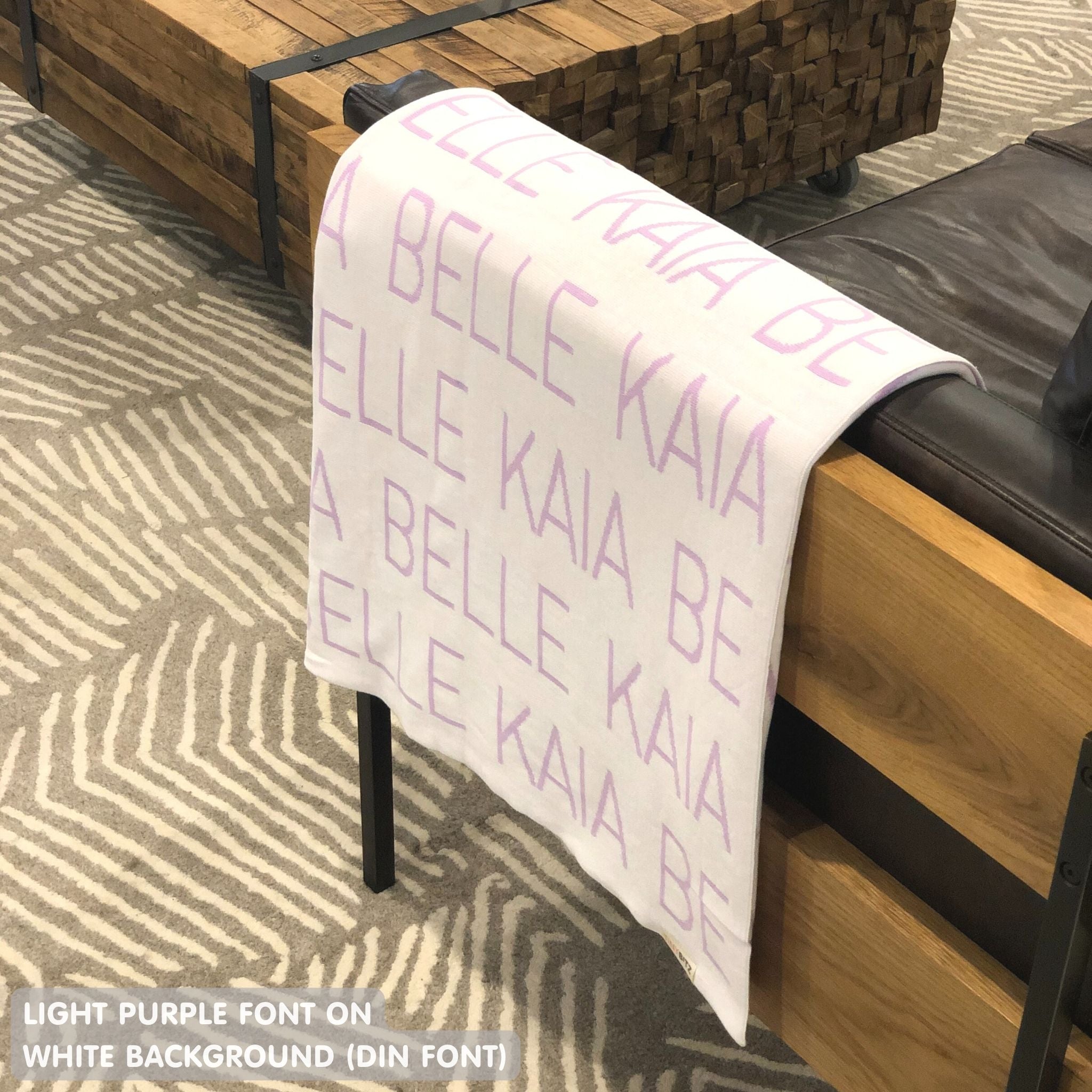Custom name blanket in white and light pink draped over a chair makes the best personalized home decor.
