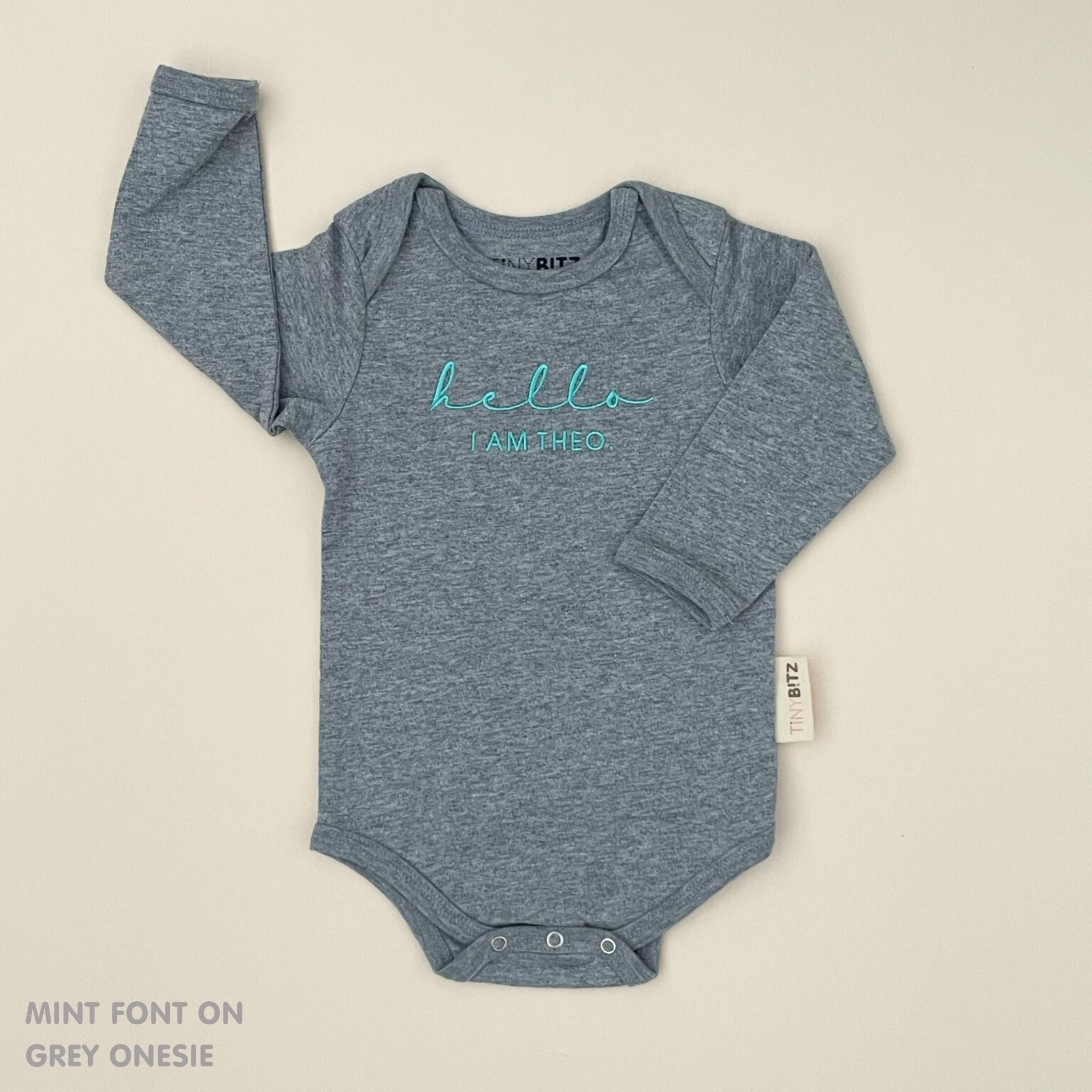 TinyBitz Personalised baby onesie with embroidered name in soft grey cotton, perfect for birth announcements and newborn photos.