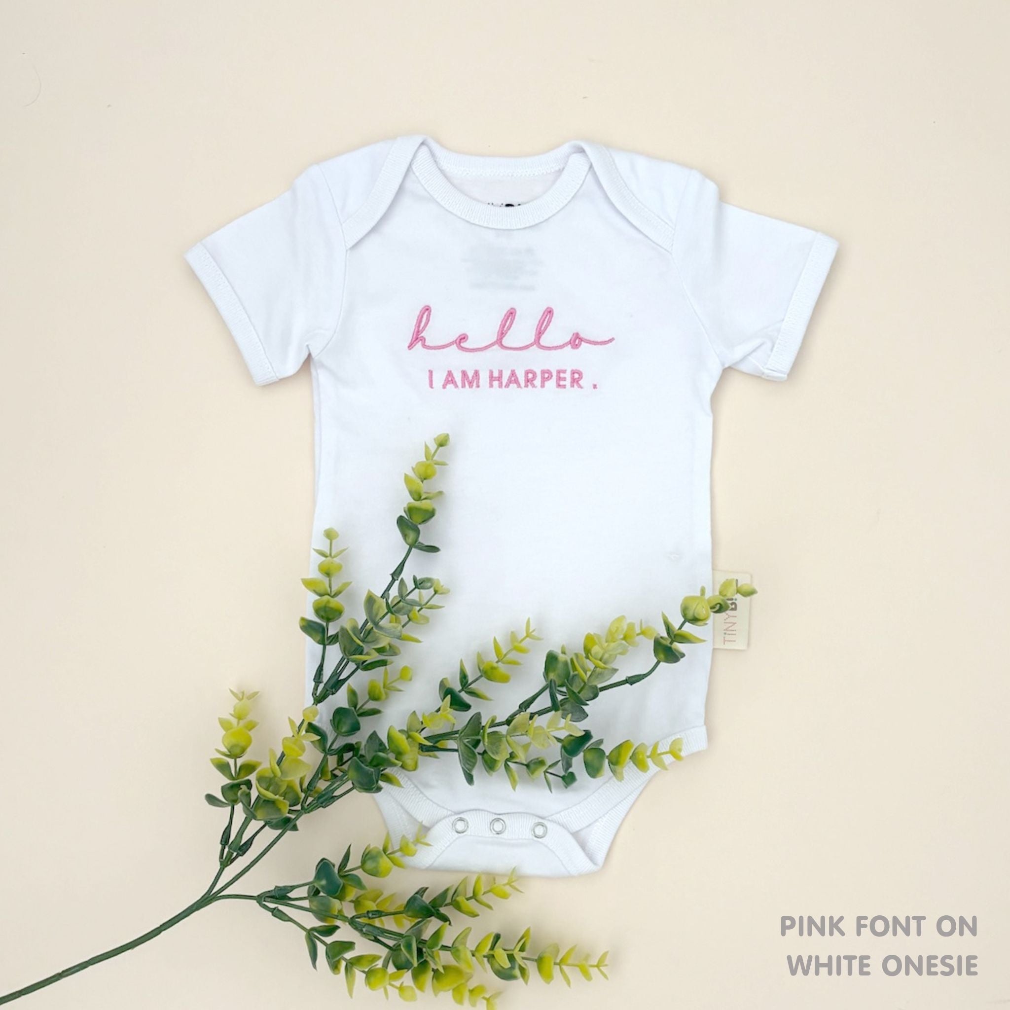 TinyBitz Personalised baby onesie with embroidered name in soft white cotton, perfect for birth announcements and newborn photos.