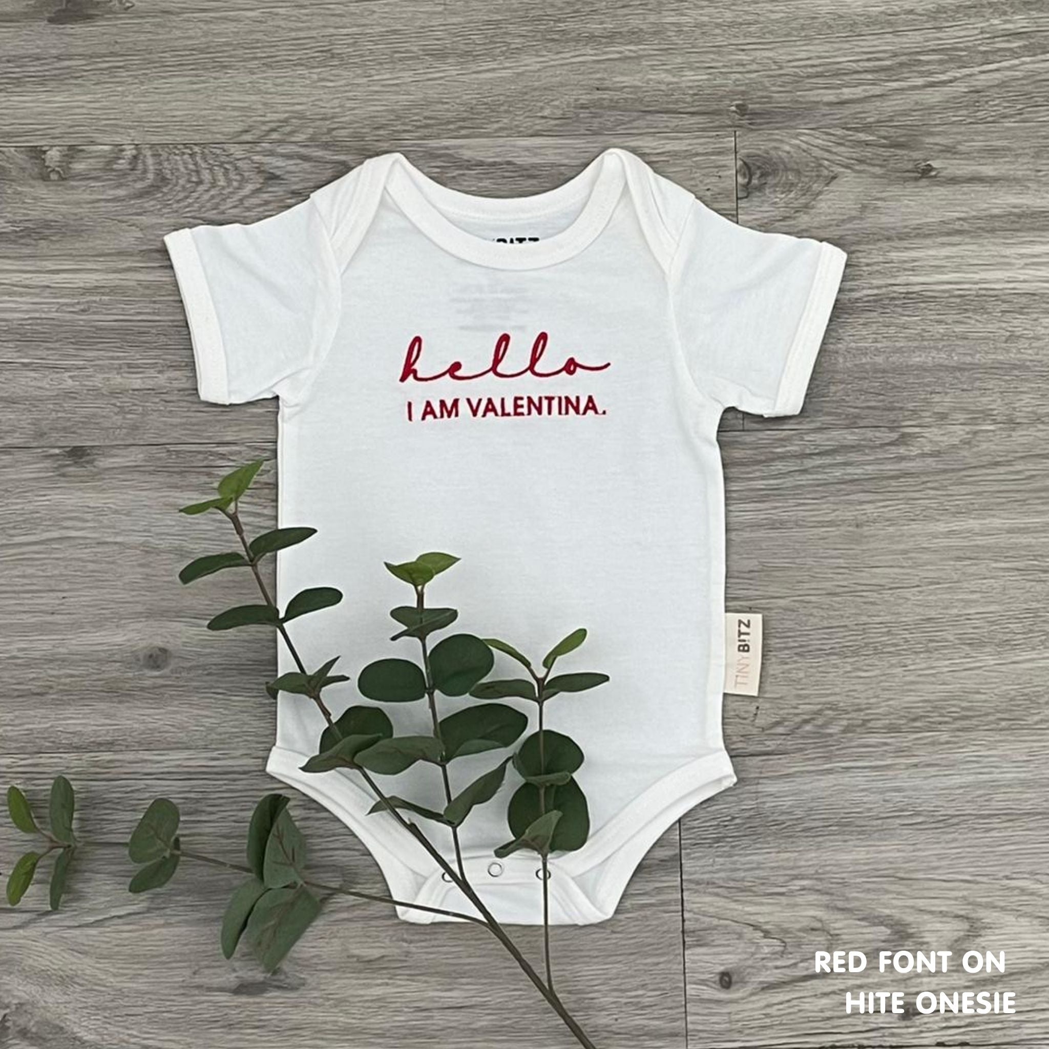 Organic cotton baby onesie with custom name, ideal for birth announcements, baby shower gifts, and keepsakes by TinyBitz.