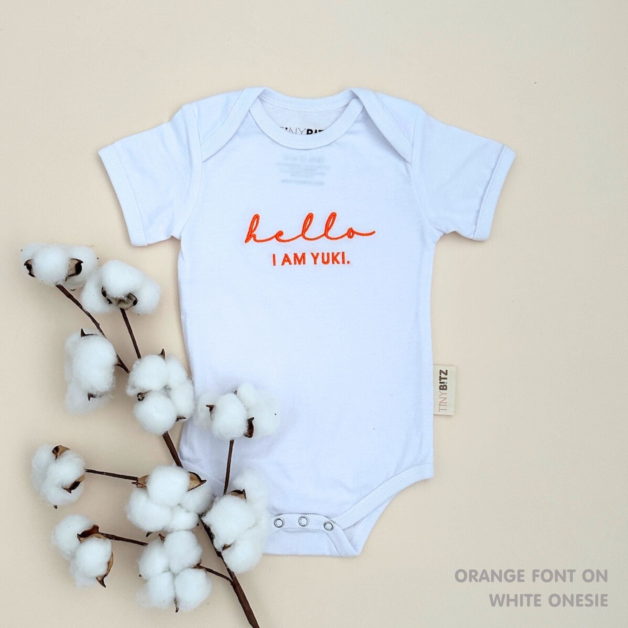 Custom name onesie in white, personalised baby clothing made with soft breathable fabric by TinyBitz.