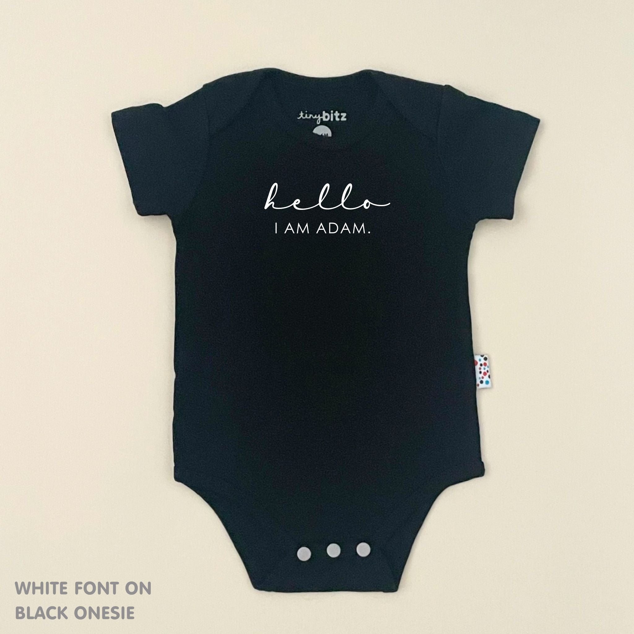 Organic cotton baby onesie with custom name, ideal for birth announcements, baby shower gifts, and keepsakes by TinyBitz.