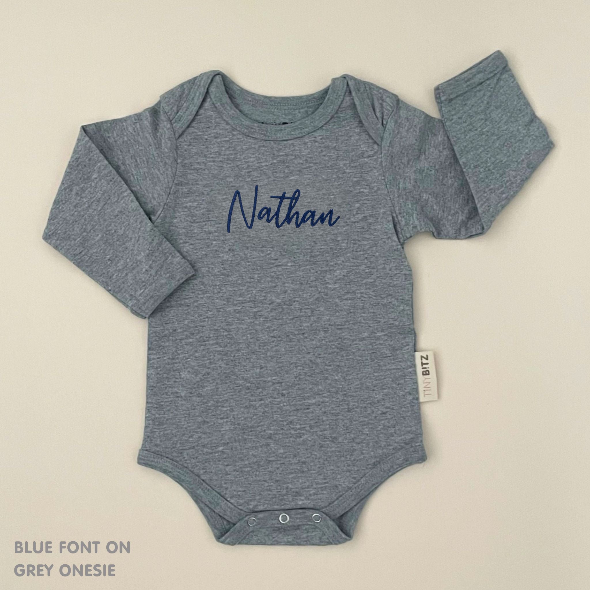 Organic cotton baby onesie with custom name, ideal for birth announcements, baby shower gifts, and keepsakes by TinyBitz.