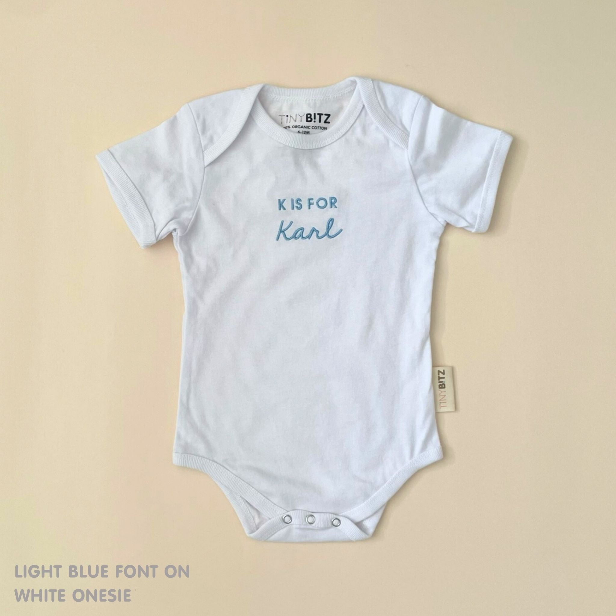 Organic cotton baby onesie with custom name, ideal for birth announcements, baby shower gifts, and keepsakes by TinyBitz.