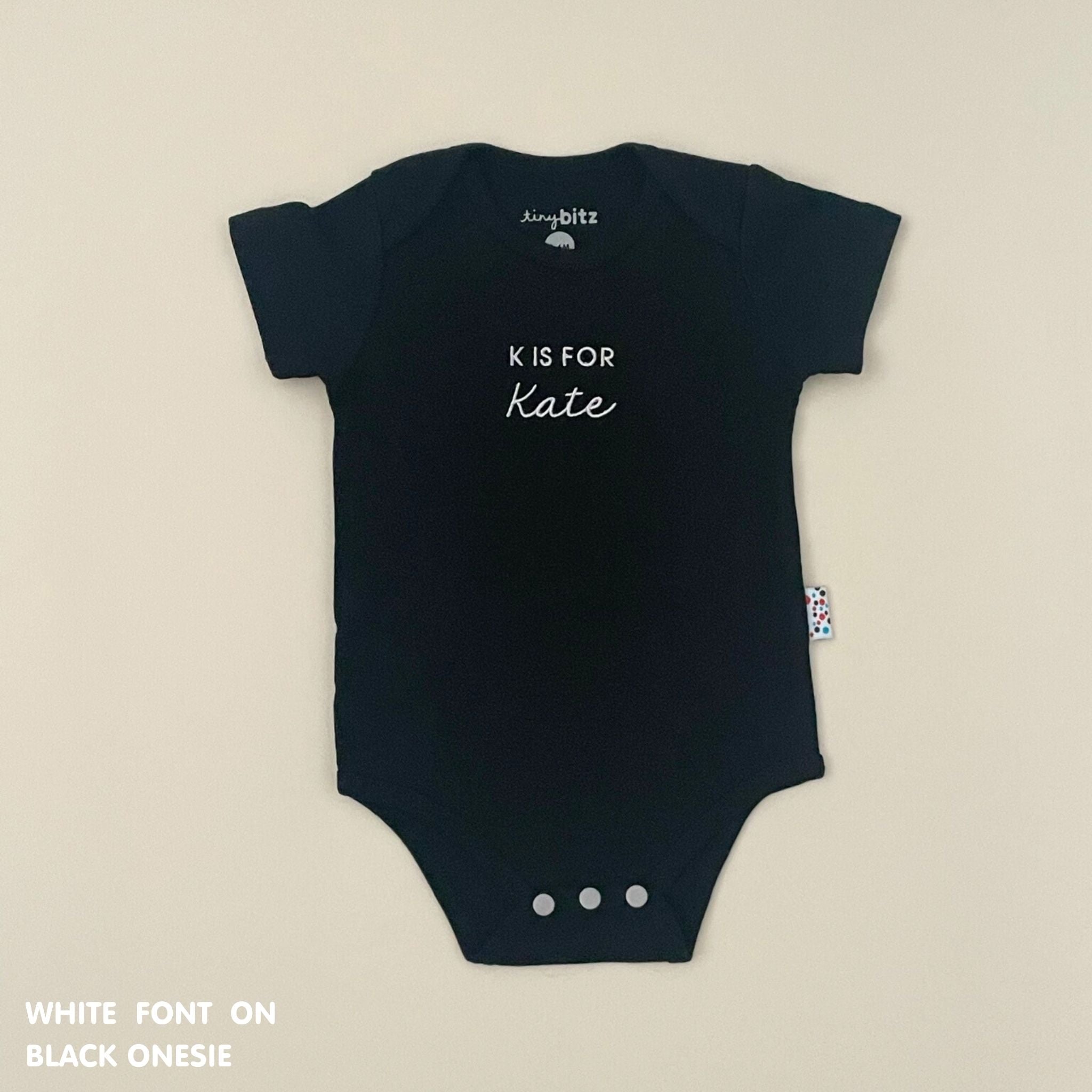 Organic cotton baby onesie with custom name, ideal for birth announcements, baby shower gifts, and keepsakes by TinyBitz.