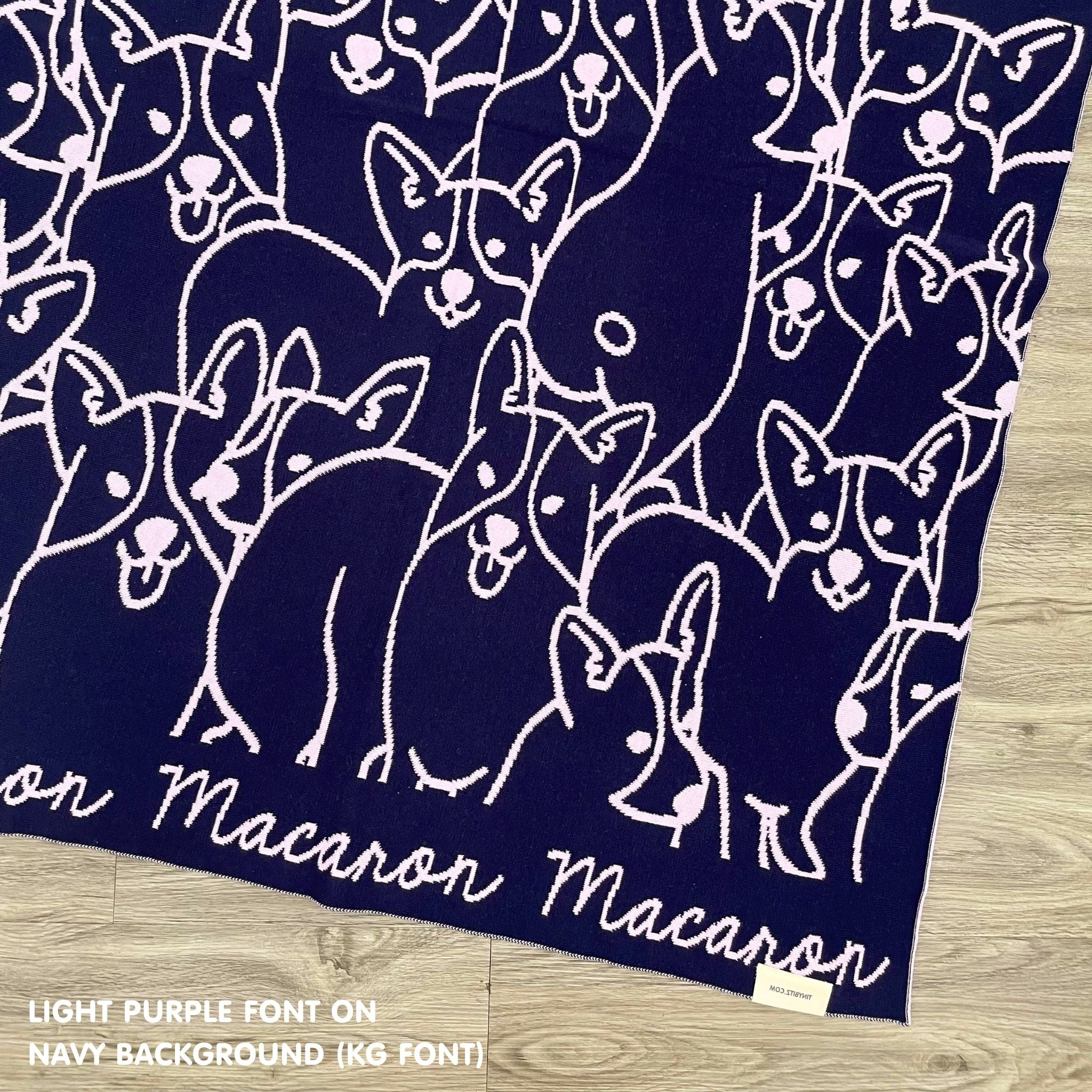 Personalised pet blanket for Corgi in navy and light purple knitted cotton, custom dog blanket by TinyBitz, styled on modern wooden dog bed.