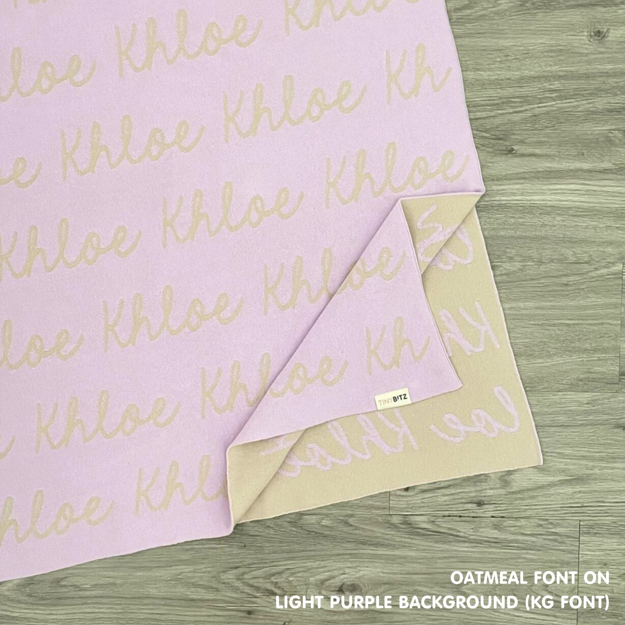 Personalised pet blanket in light purple and oatmeal knitted cotton, custom dog blanket by TinyBitz, styled on modern wooden dog bed.