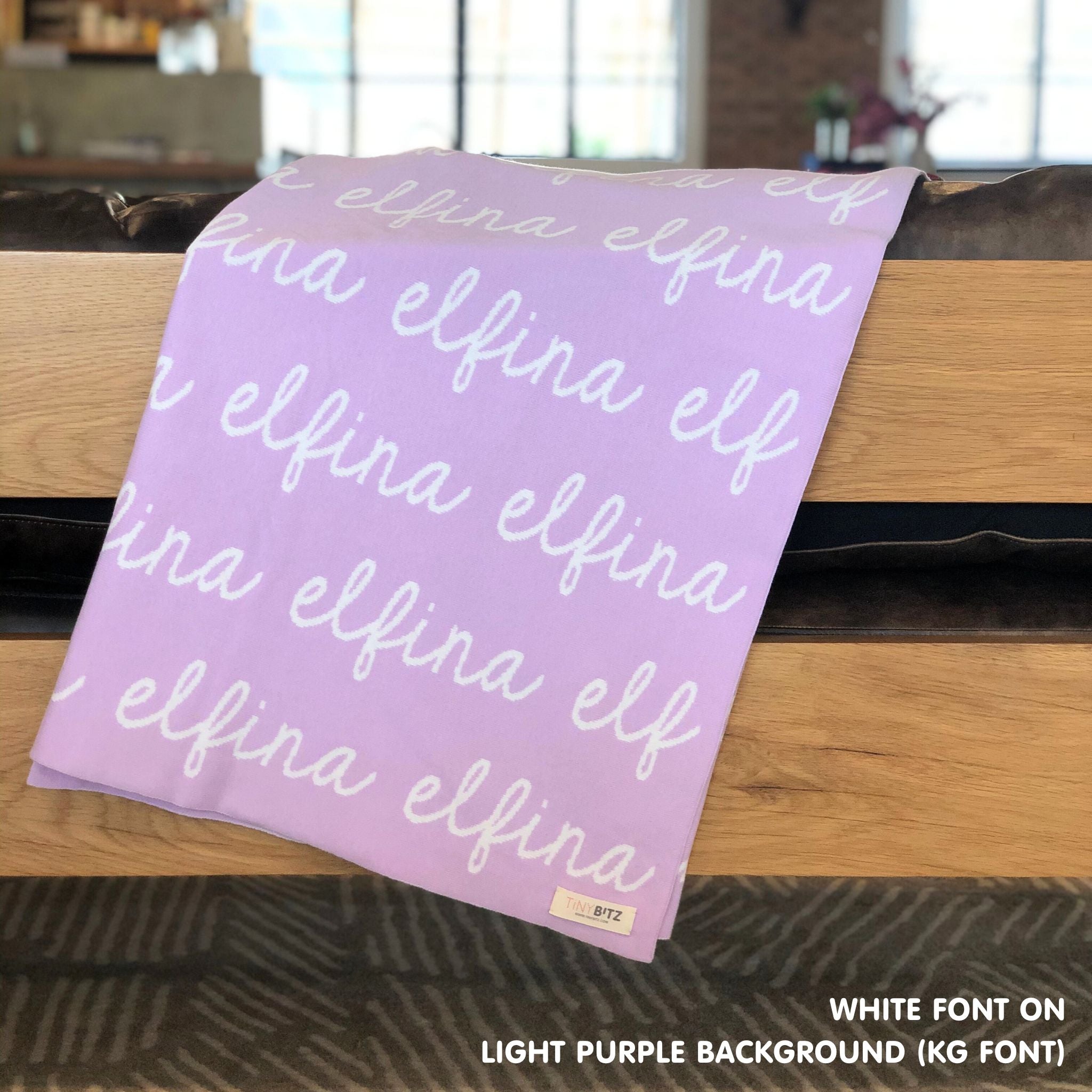 Personalised pet blanket in light purple and white knitted cotton, custom dog blanket by TinyBitz, styled on modern wooden dog bed.