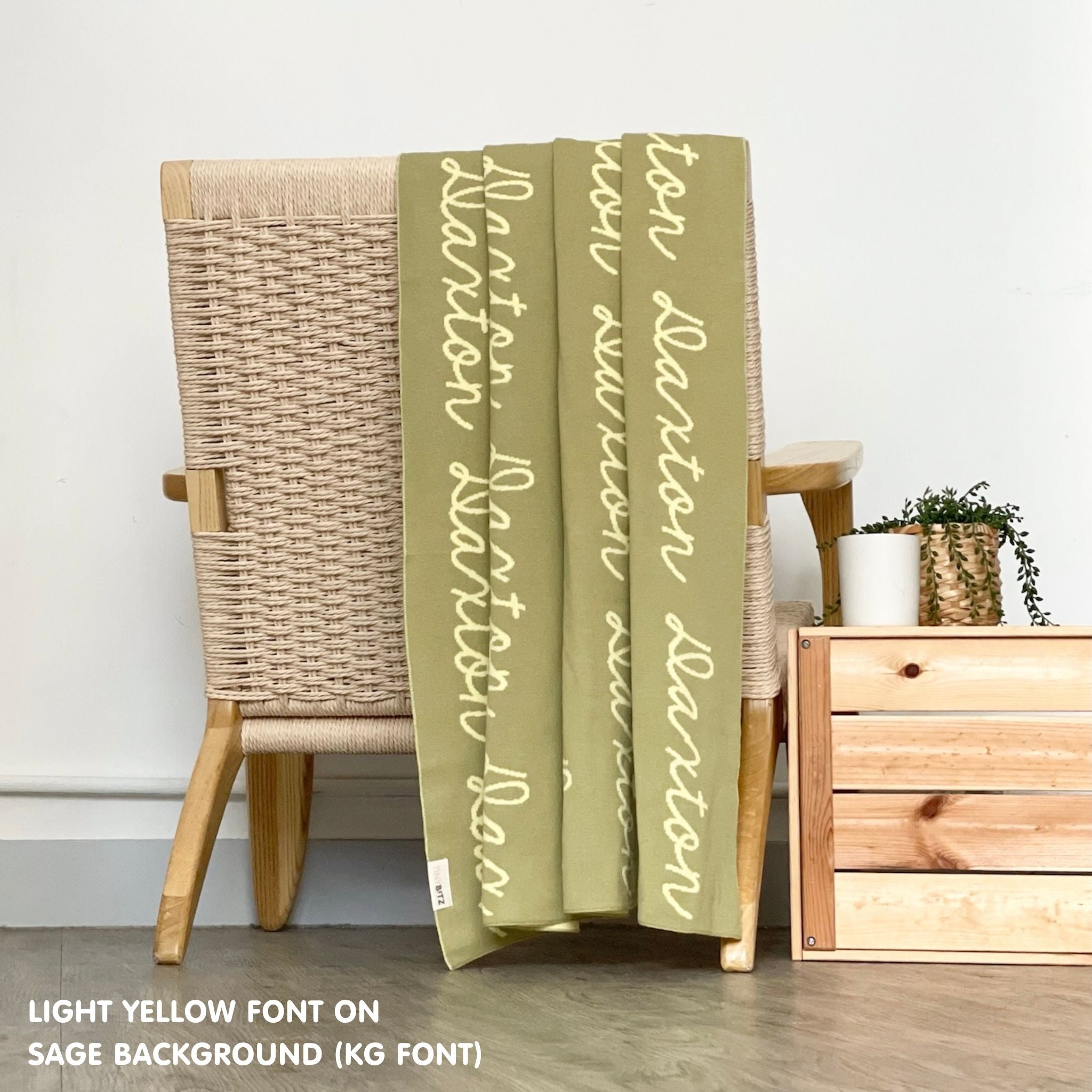 Personalised pet blanket for in sage and light yellow knitted cotton, custom dog blanket by TinyBitz, styled on modern wooden dog bed.