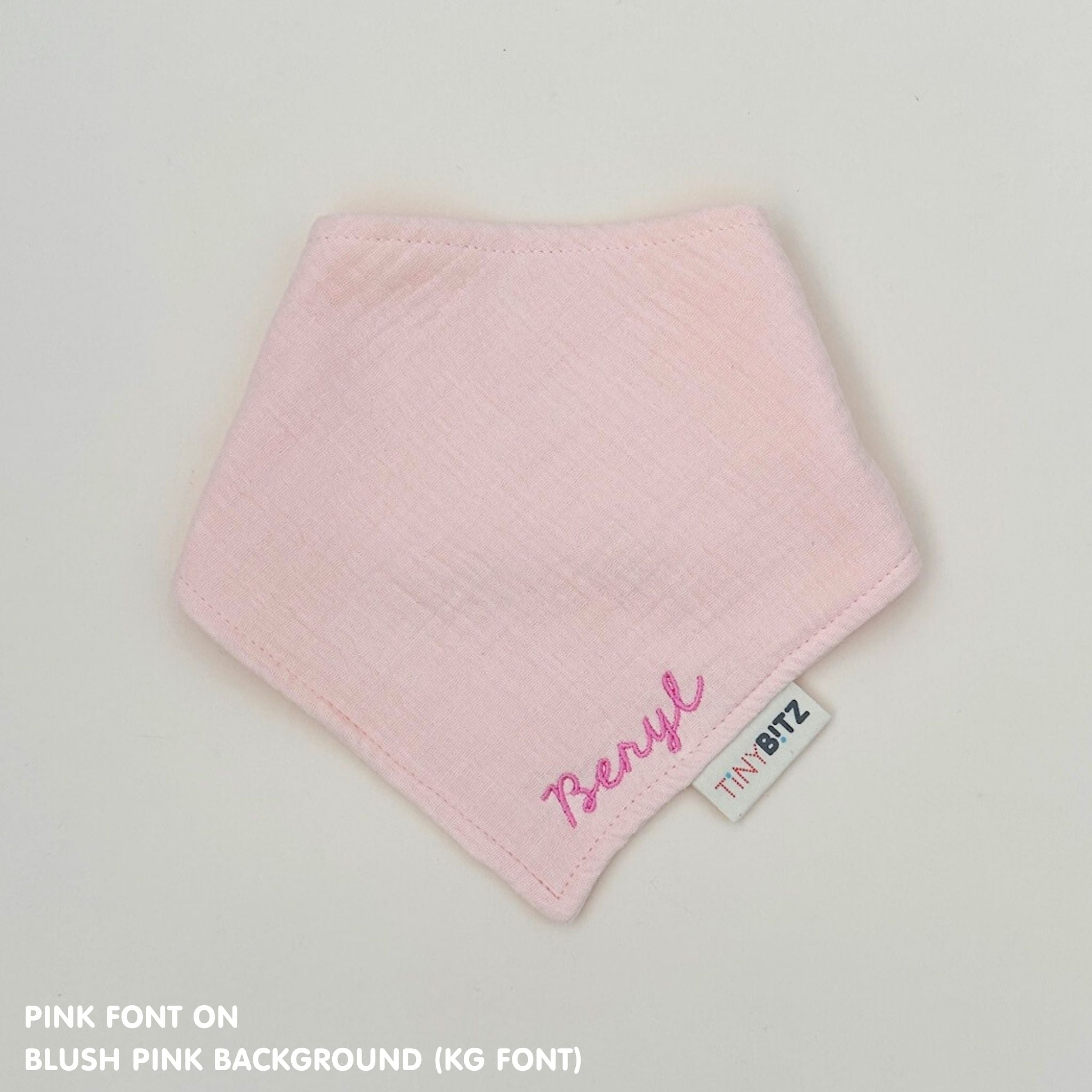 Custom baby bib in blush pink with embroidered name, personalised baby gift made from breathable muslin by TinyBitz.