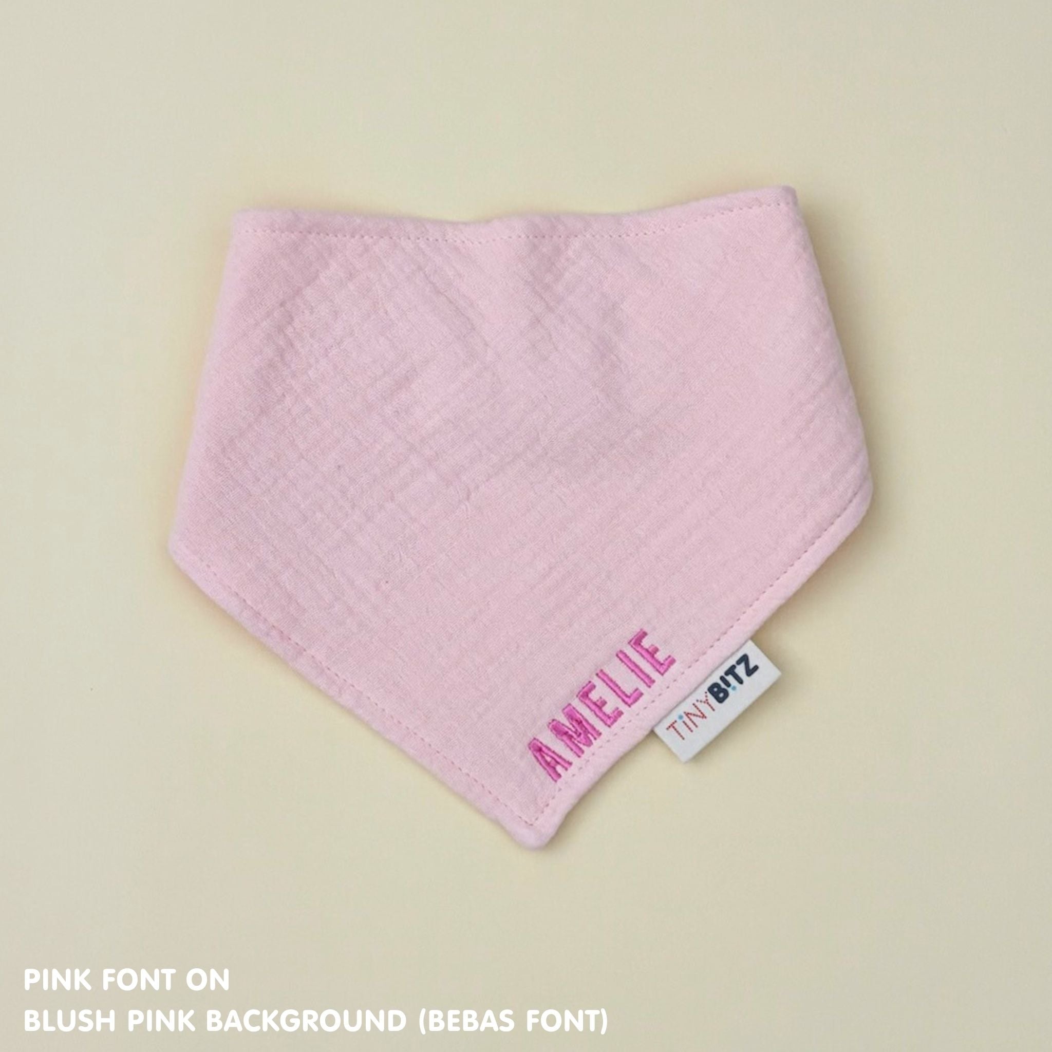 Organic personalised bib for babies in blush pink, featuring baby name in script font, unique baby gift idea by TinyBitz.