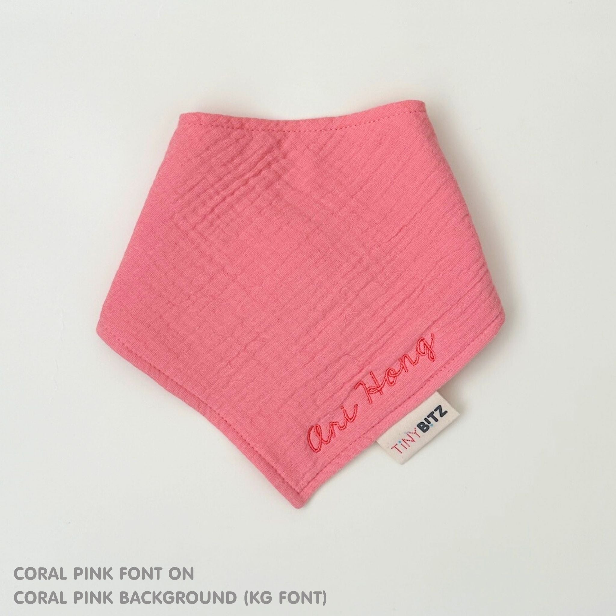 Organic cotton baby bib with name stitched on coral pink fabric, personalised baby gifts by TinyBitz.