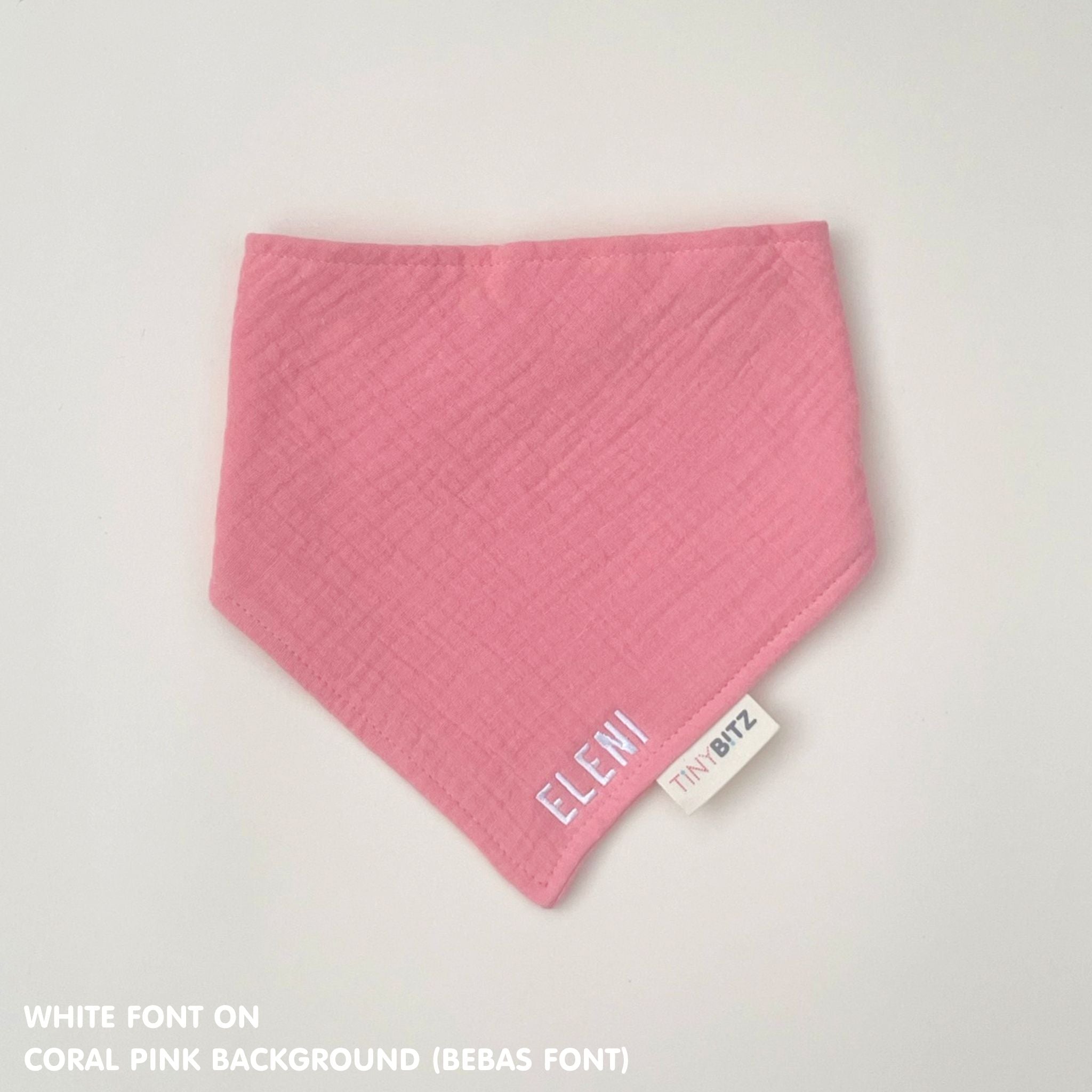 Personalised baby bib in coral pink with name embroidery, custom organic cotton bib by TinyBitz, thoughtful baby shower gift.