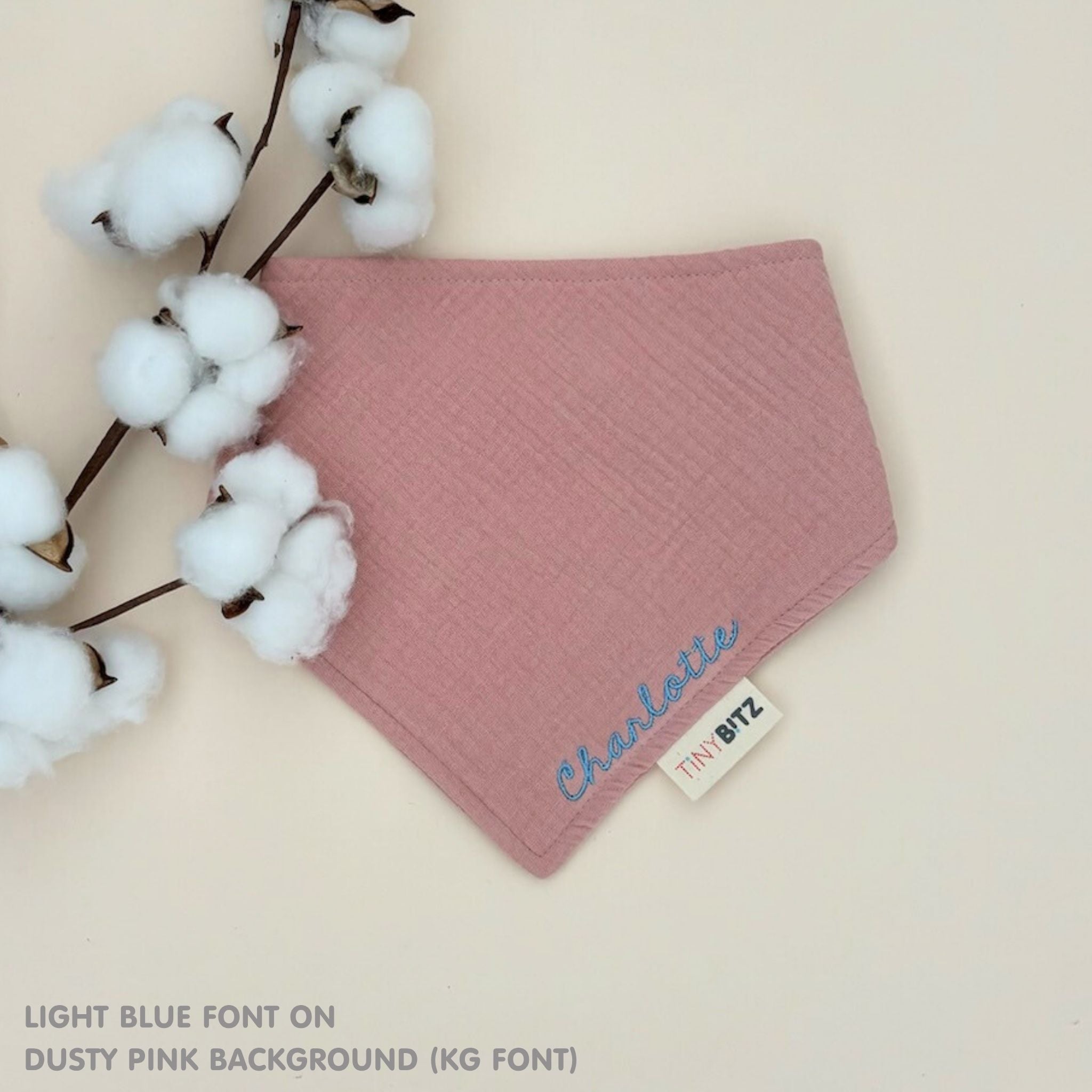 Custom baby bib in dusty pink with embroidered name, personalised baby gift made from breathable muslin by TinyBitz.