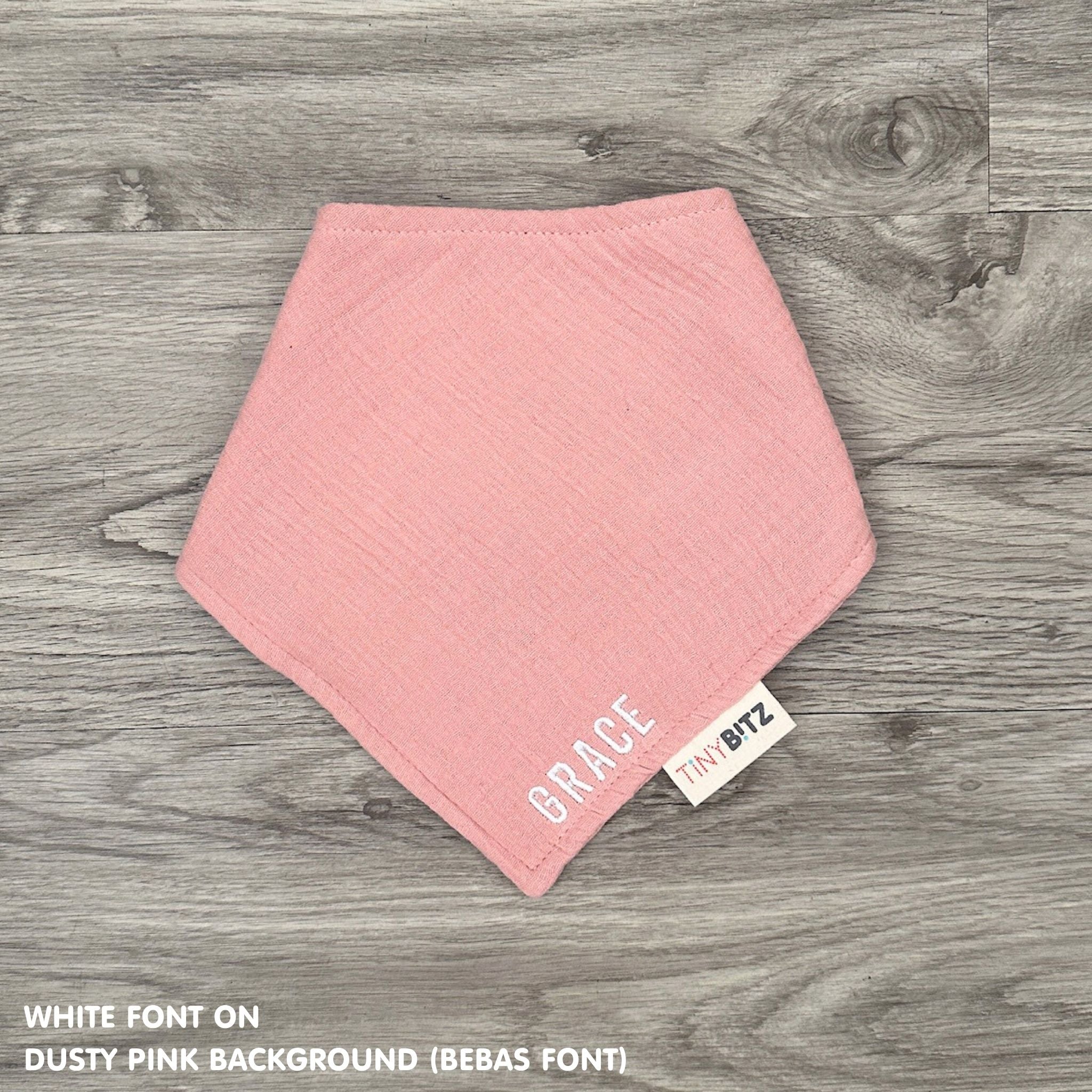 Custom baby bib in dusty pink with embroidered name, personalised baby gift made from breathable muslin by TinyBitz.