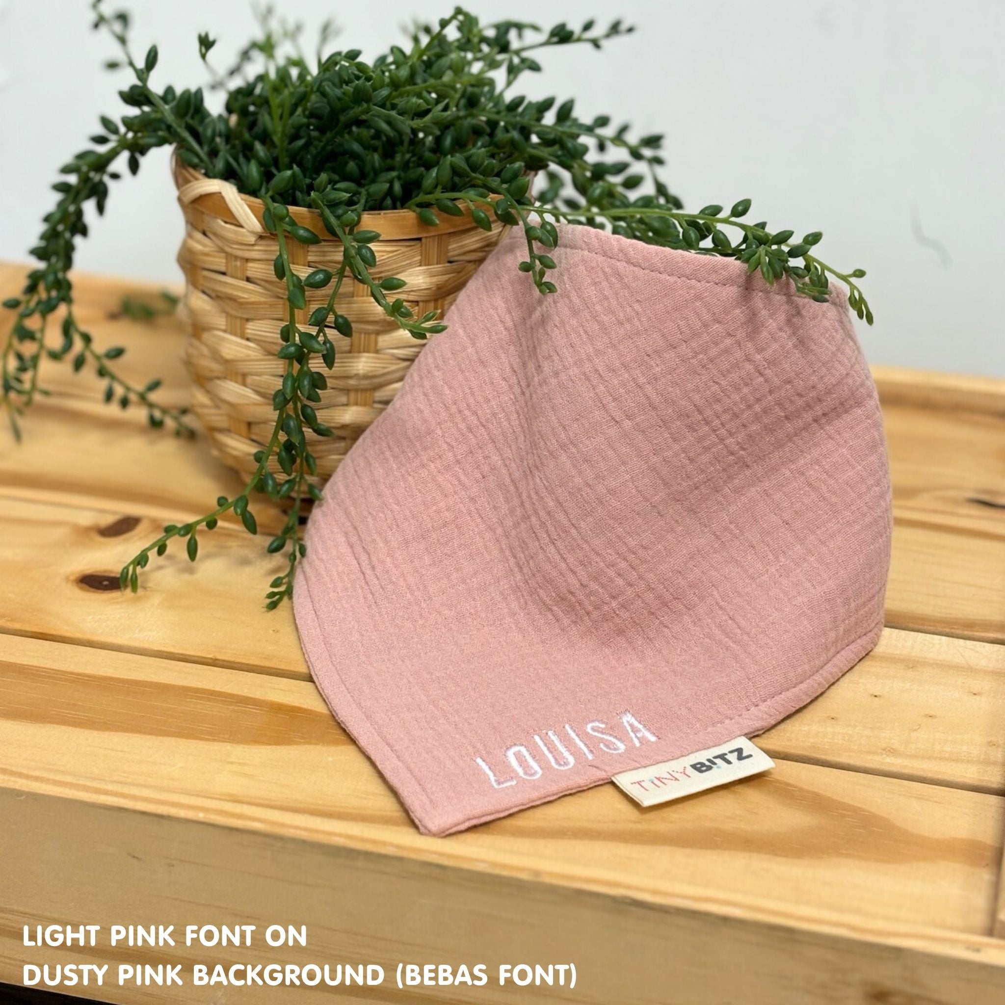 Personalized dusty pink organic muslin bib with custom name embroidery, perfect for baby gifts and keepsake accessories.