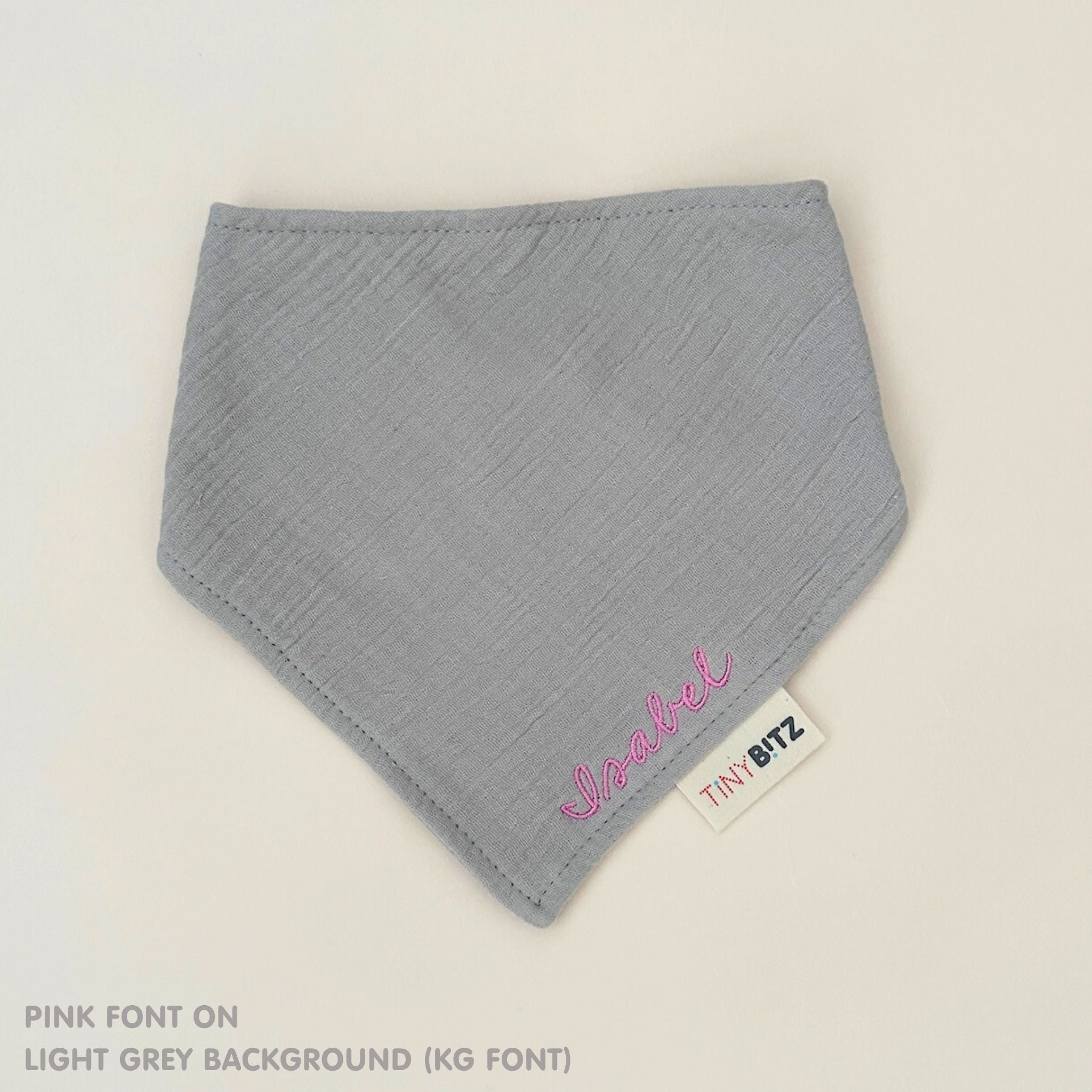 Organic cotton baby bib with name stitched on light grey fabric, personalised baby gifts by TinyBitz.