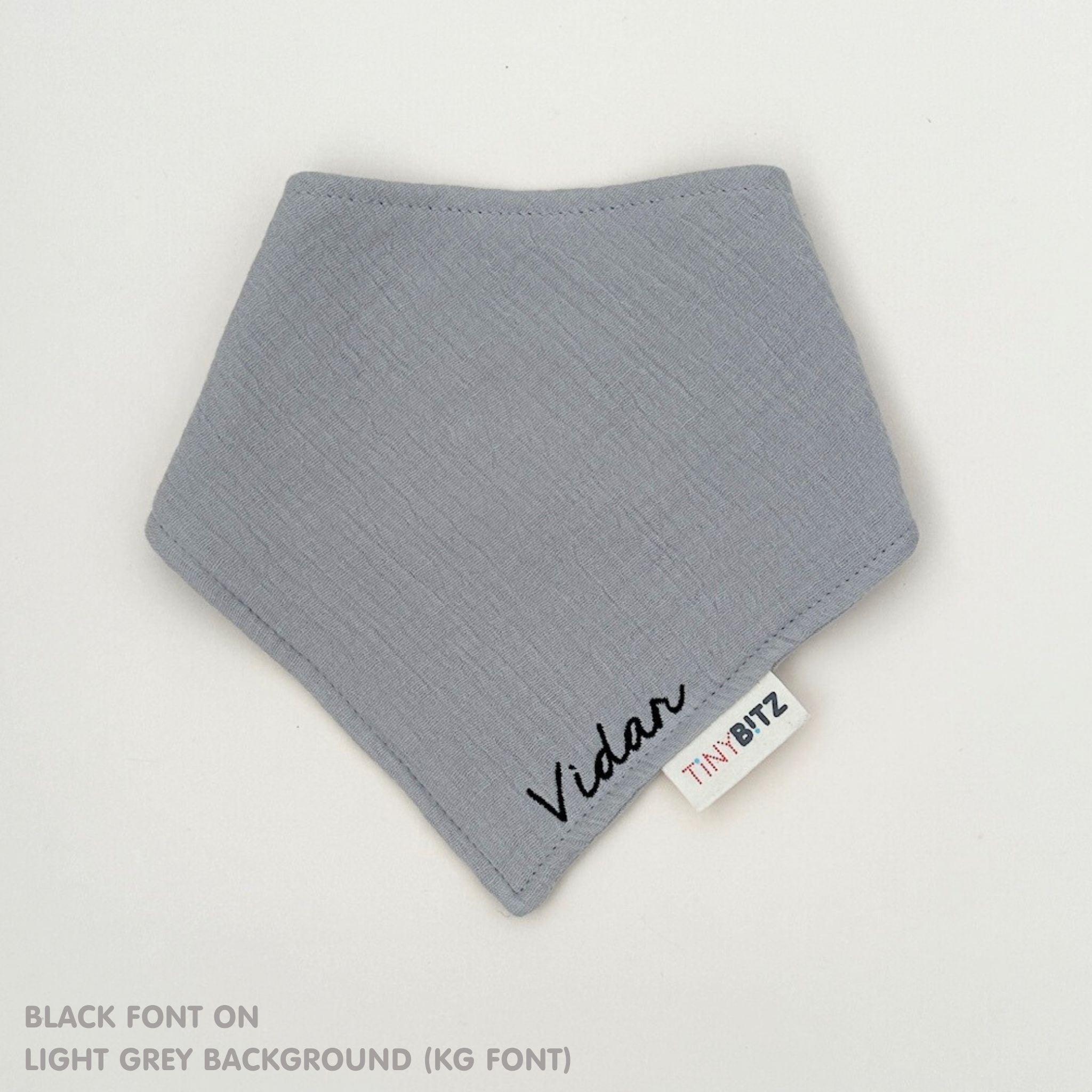 Organic personalised bib for babies in light grey, featuring baby name in script font, unique baby gift idea by TinyBitz.