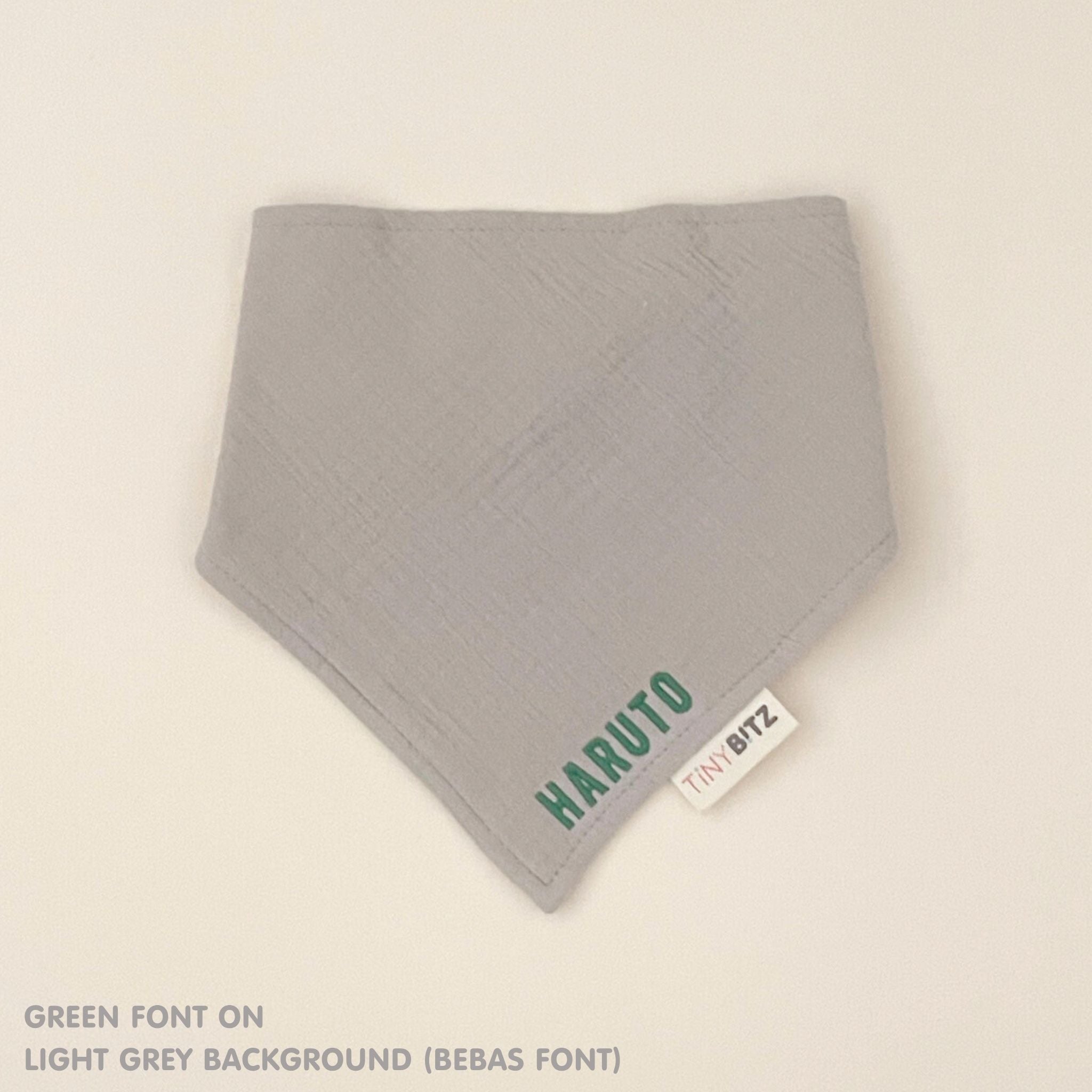 Organic cotton baby bib with name stitched on light grey fabric, personalised baby gifts by TinyBitz.