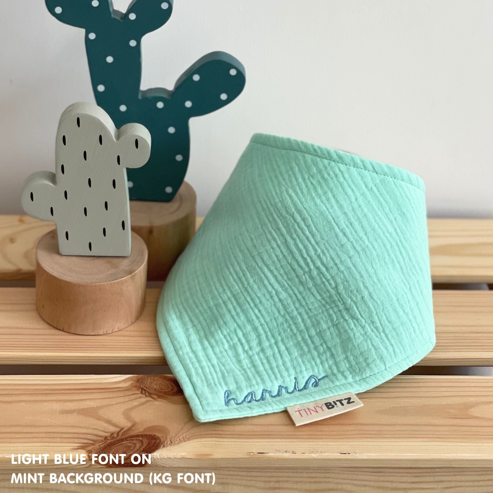 Personalized mint organic muslin bib with custom name embroidery, perfect for baby gifts and keepsake accessories.