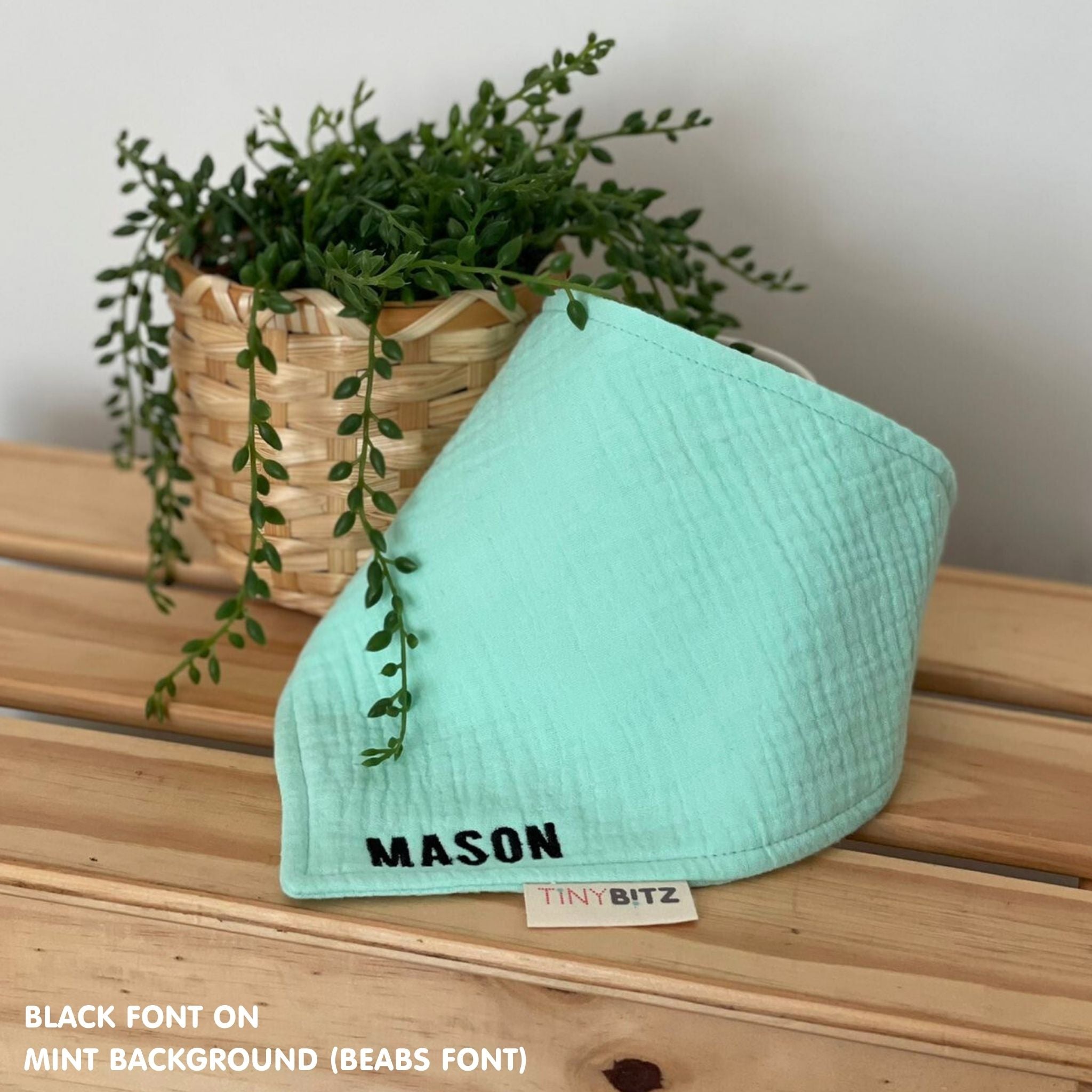 Personalized mint organic muslin bib with custom name embroidery, perfect for baby gifts and keepsake accessories.