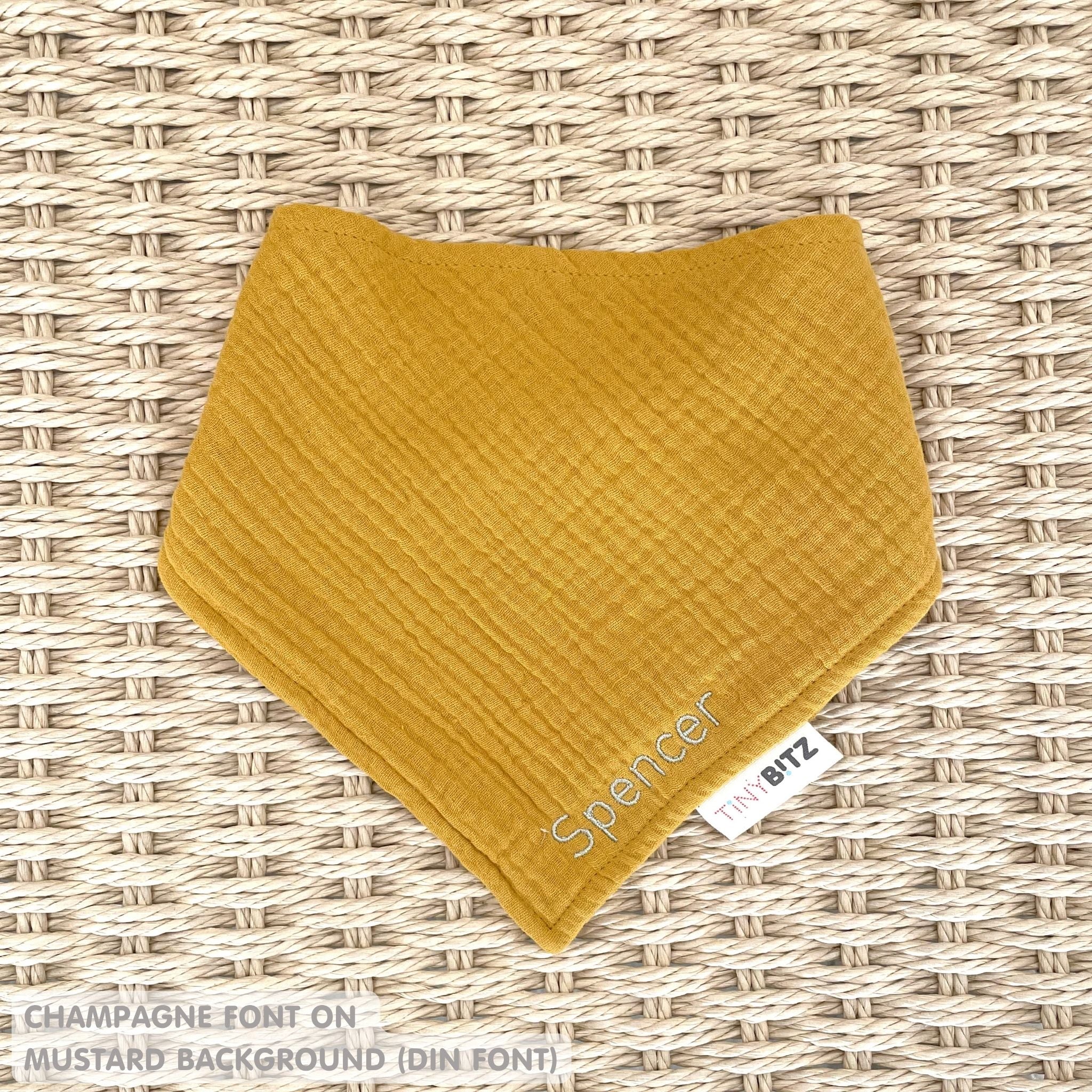 Organic cotton baby bib with name stitched on mustard fabric, personalised baby gifts by TinyBitz.