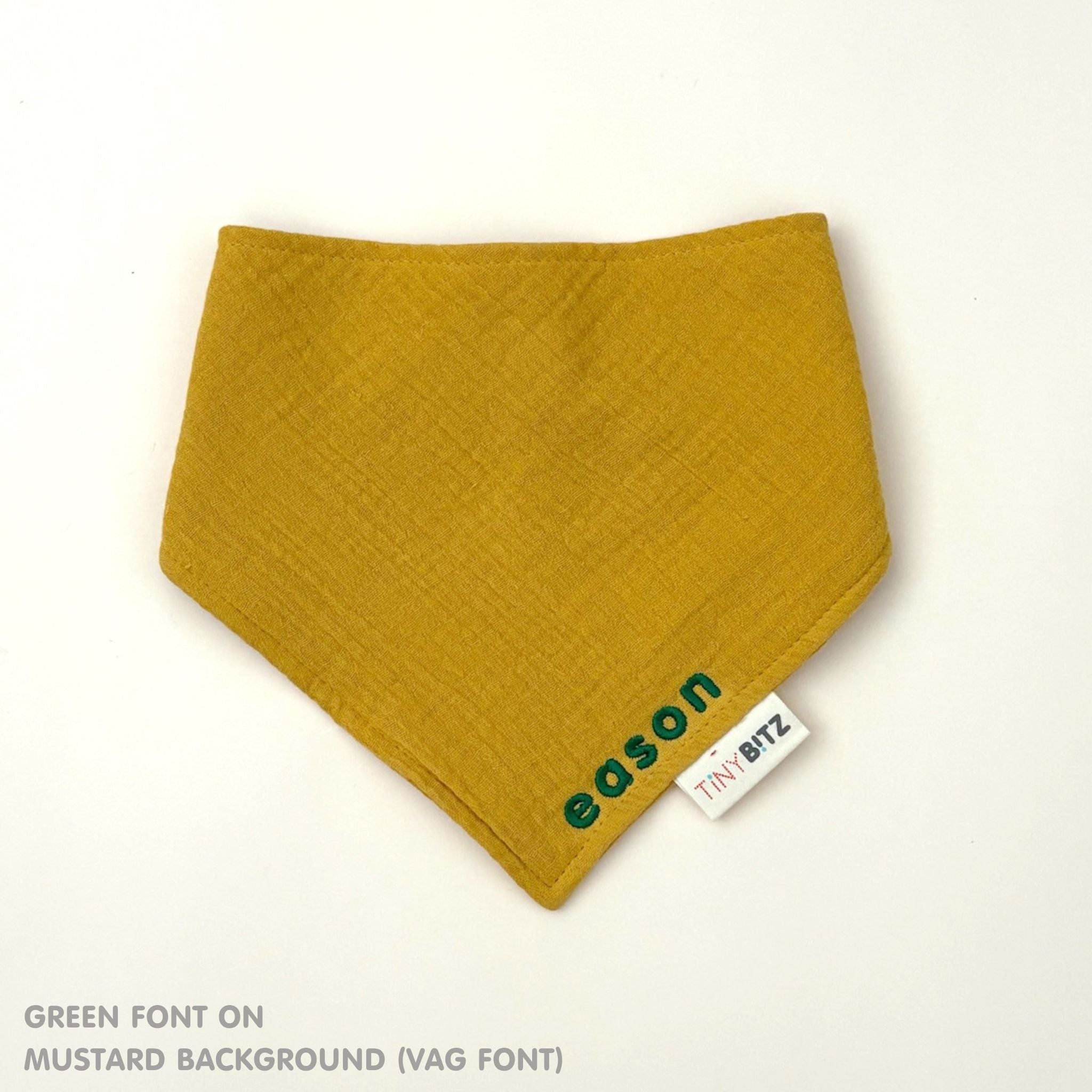 Organic personalised bib for babies in mustard, featuring baby name in script font, unique baby gift idea by TinyBitz.