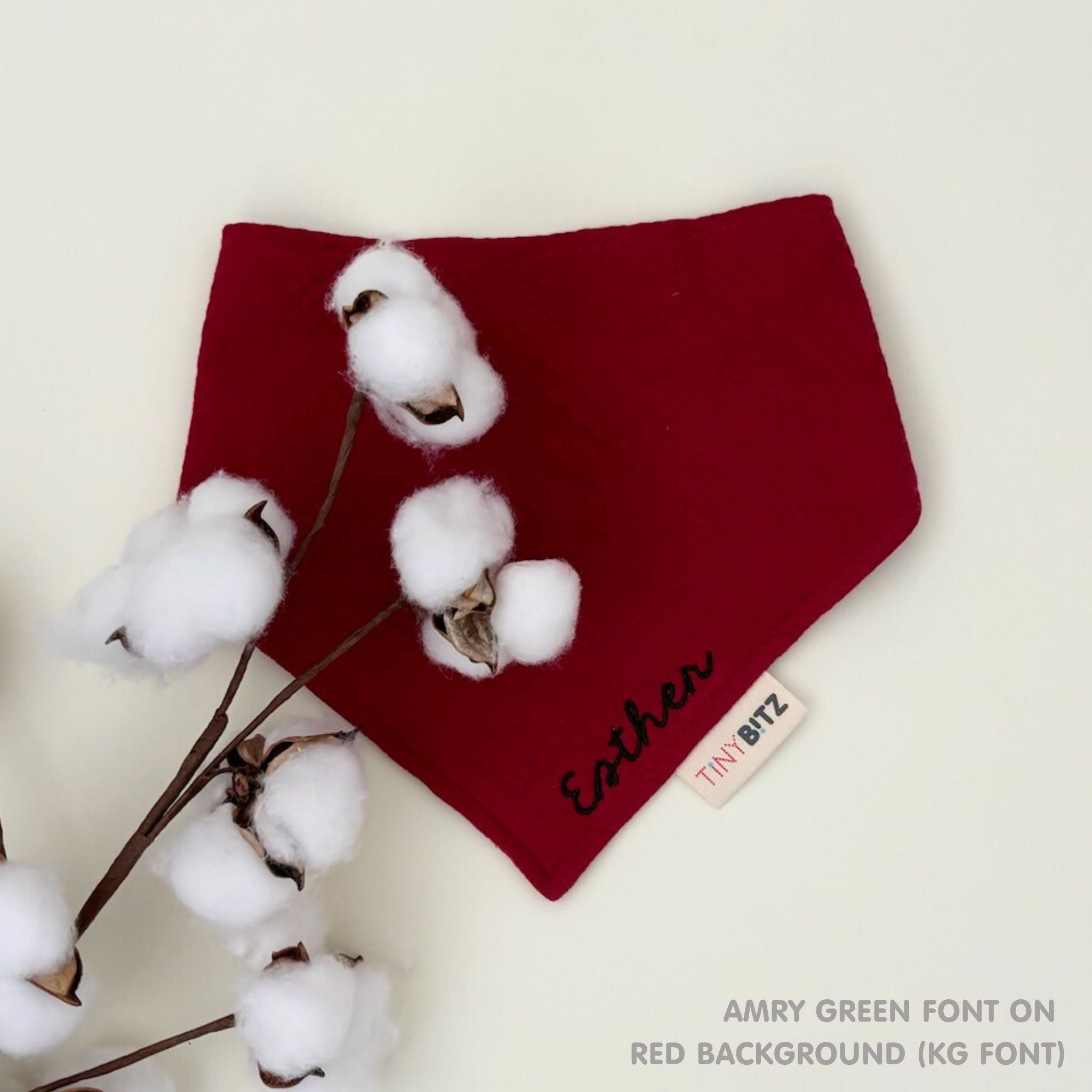 Custom baby bib in red with embroidered name, personalised baby gift made from breathable muslin by TinyBitz.