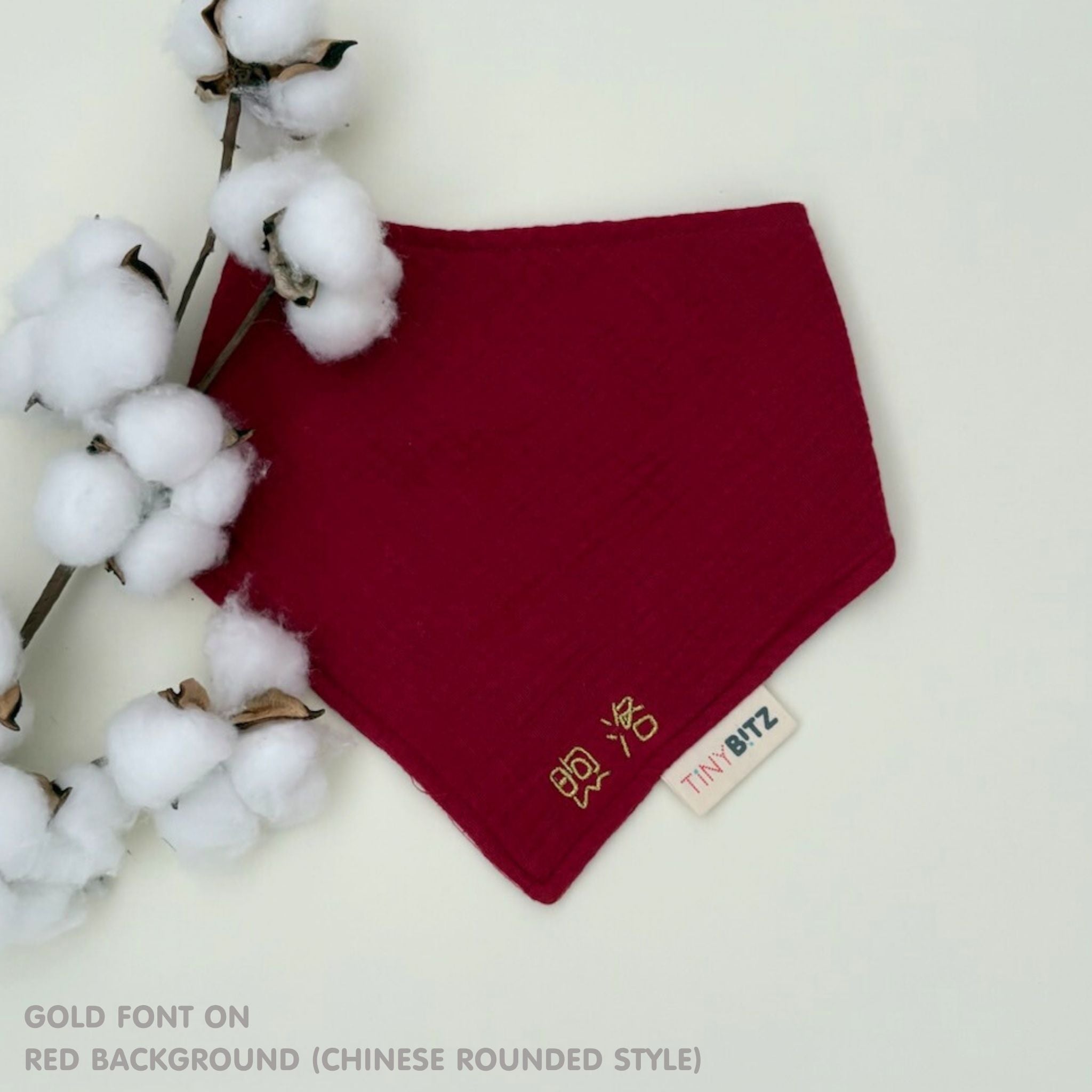 Personalized red organic muslin bib with custom name embroidery, perfect for baby gifts and keepsake accessories.