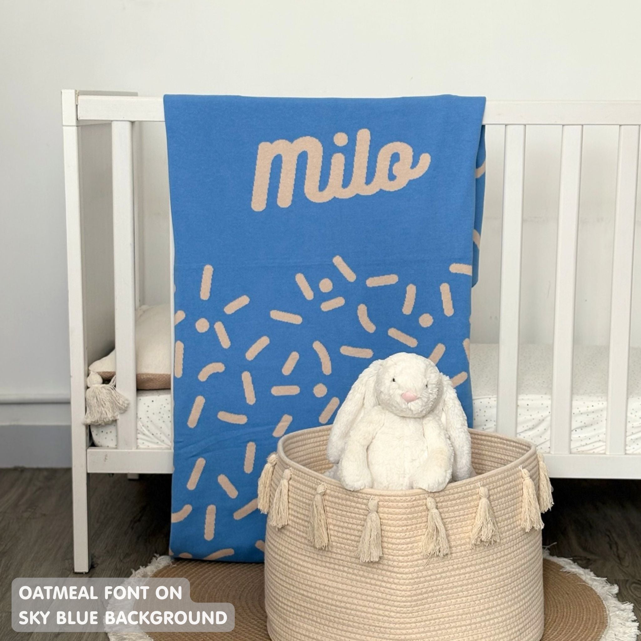 Knitted baby blanket in sky blue and oatmeal with a confetti pattern, customised with baby's name, made by TinyBitz.