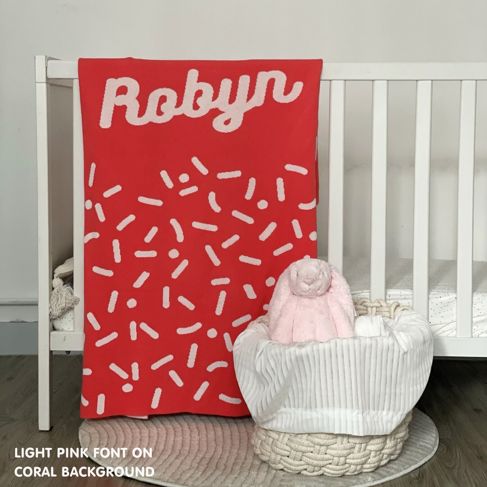 TinyBitz personalized baby name blanket, knitted in coral and light pink with a confetti pattern, perfect baby shower gift!