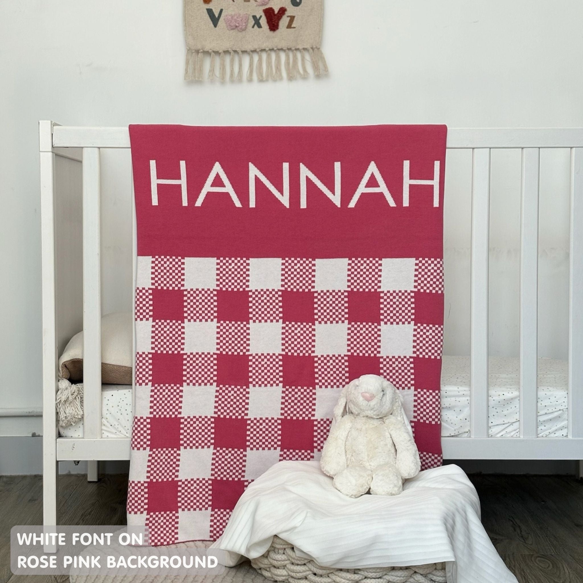 Knitted baby blanket in rose pink and white with a check pattern, customised with baby's name, made by TinyBitz.