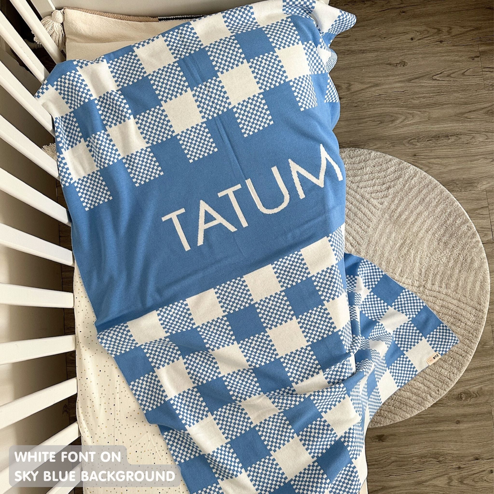 Knitted baby blanket in sky blue and white with a check pattern, customised with baby's name, made by TinyBitz.
