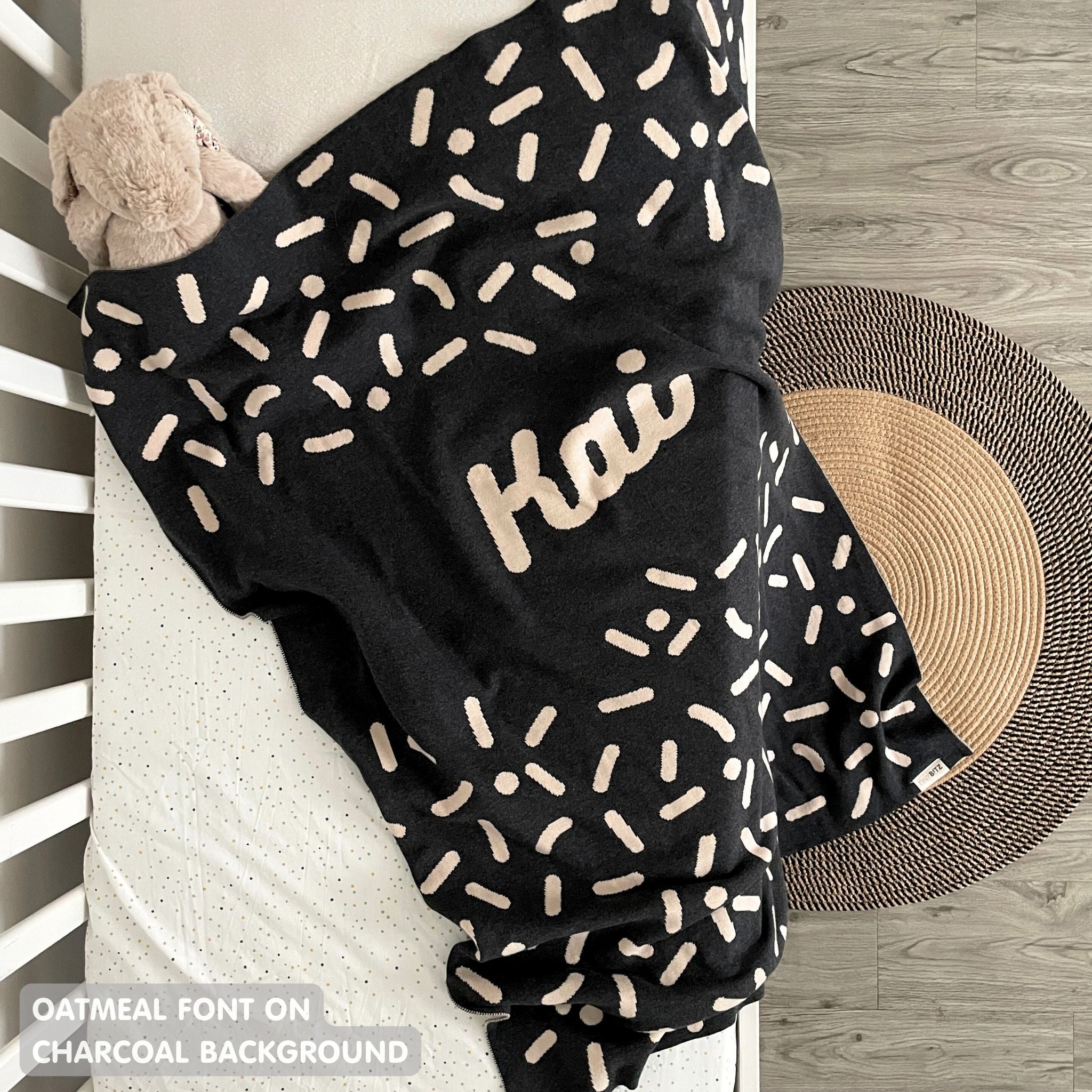 TinyBitz personalized name blanket in charcoal and oatmeal with a confetti pattern, perfect gift for newborn babies and kids.
