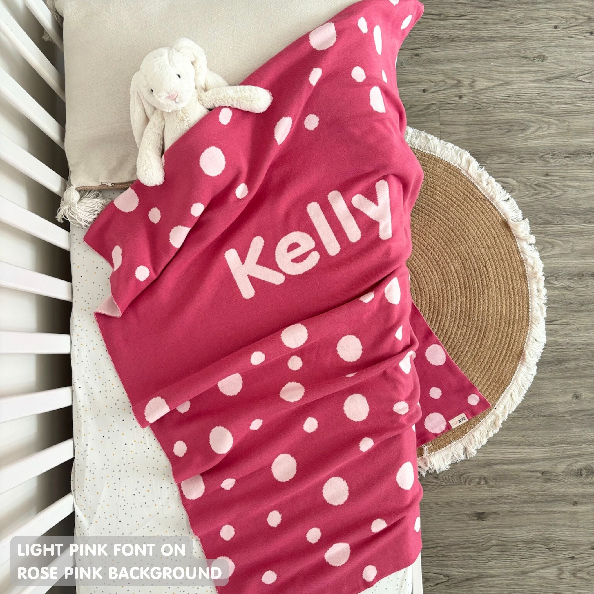 Knitted baby blanket in rose pink and light pink with a dot pattern, customised with baby's name, made by TinyBitz.