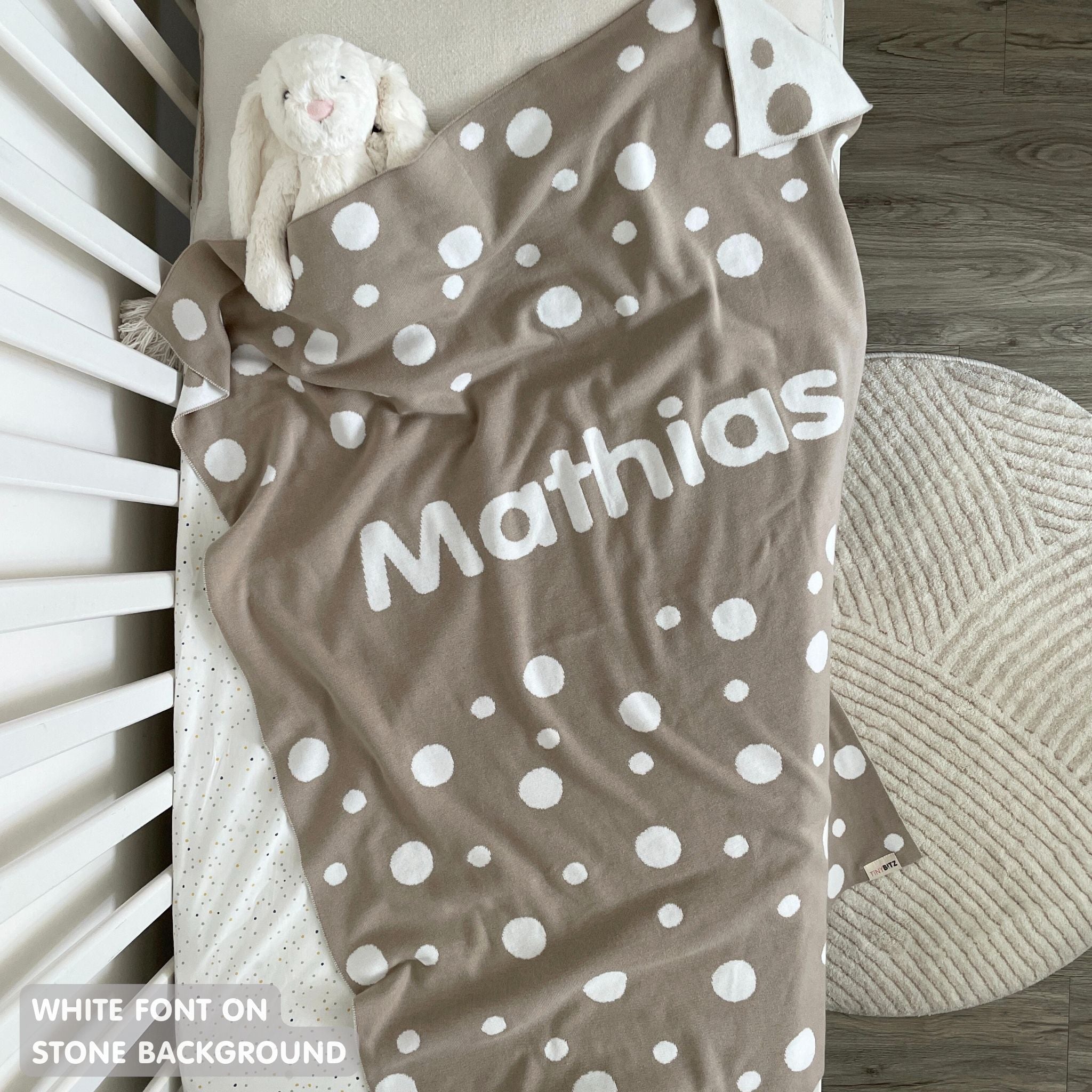 TinyBitz knitted name blanket in stone and white with a dot pattern, a lovely touch to decorate your baby's room!