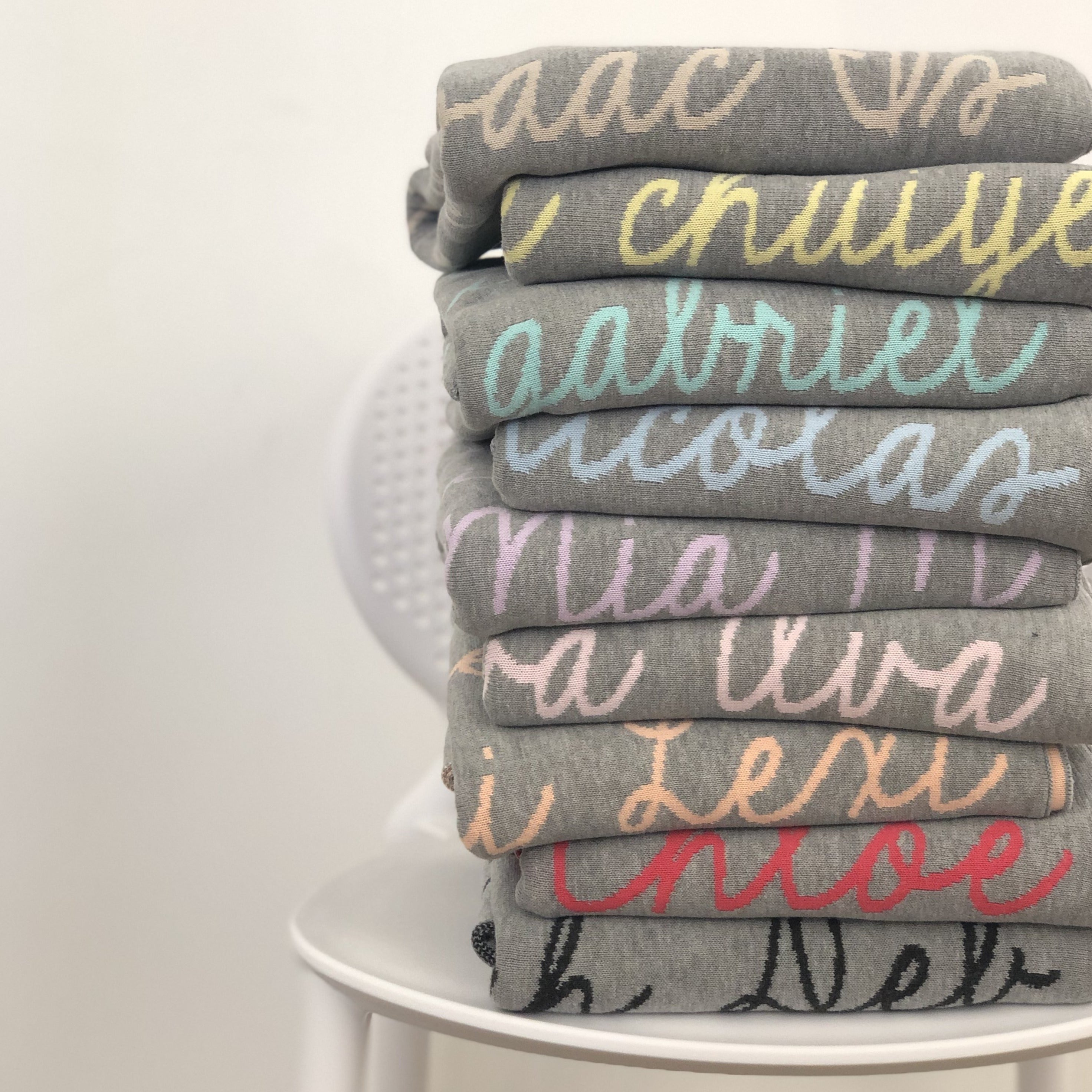 Knitted baby blanket in light grey background, customised with baby's name, made by TinyBitz.