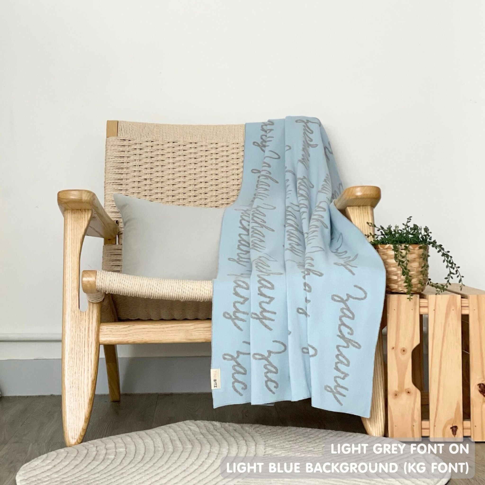 Customisable blanket with adult's name knitted in light blue and light grey, personalized by TinyBitz.