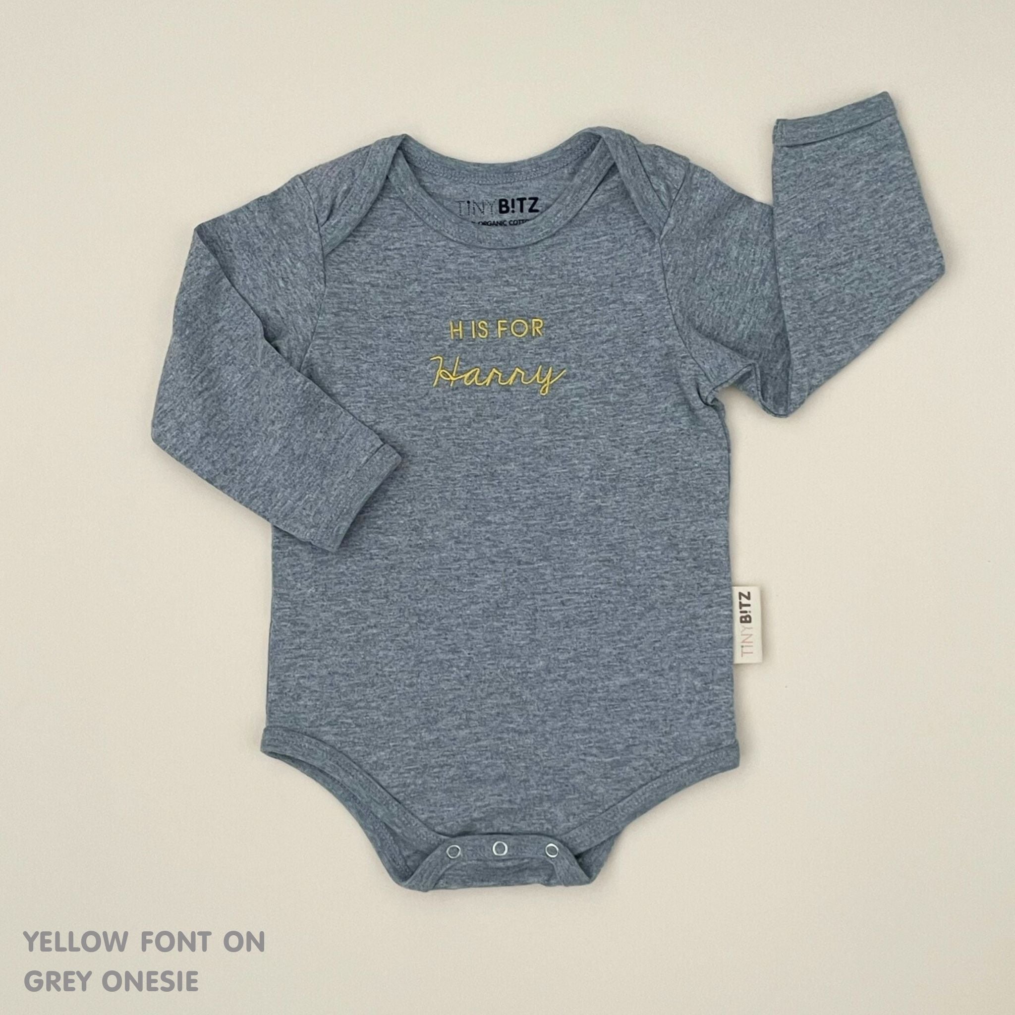 Neutral-tone personalised baby onesie featuring custom name, made-to-order newborn gift by TinyBitz.
