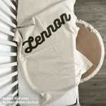 Knitted baby blanket in cream and army green with a confetti pattern, customised with baby's name, made by TinyBitz.