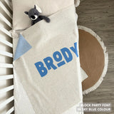 Cotton baby blanket with baby's name knitted in cream and sky blue with a confetti pattern, made by TinyBitz.