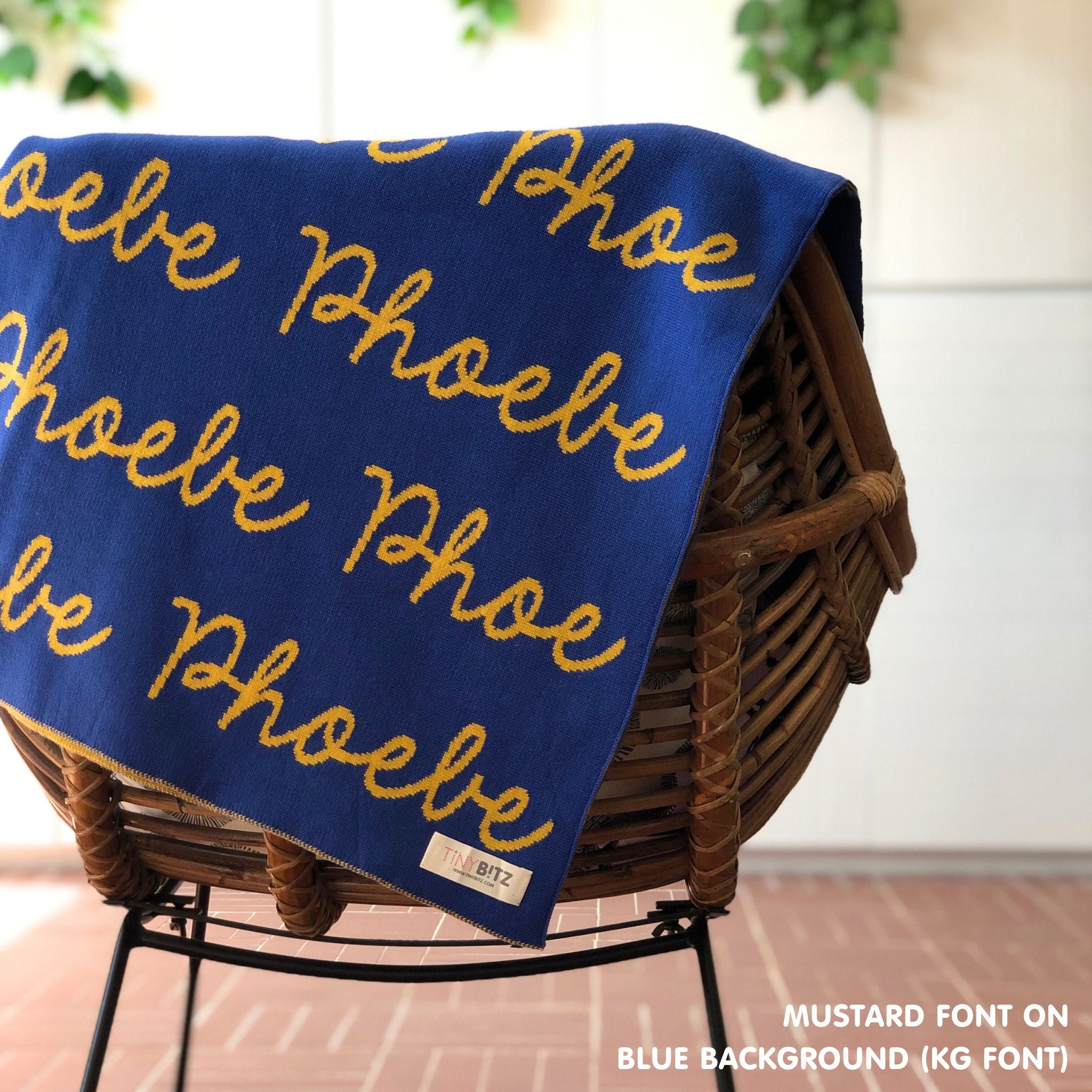 Custom name blanket in blue and mustard draped over a chair makes the best personalized home decor.