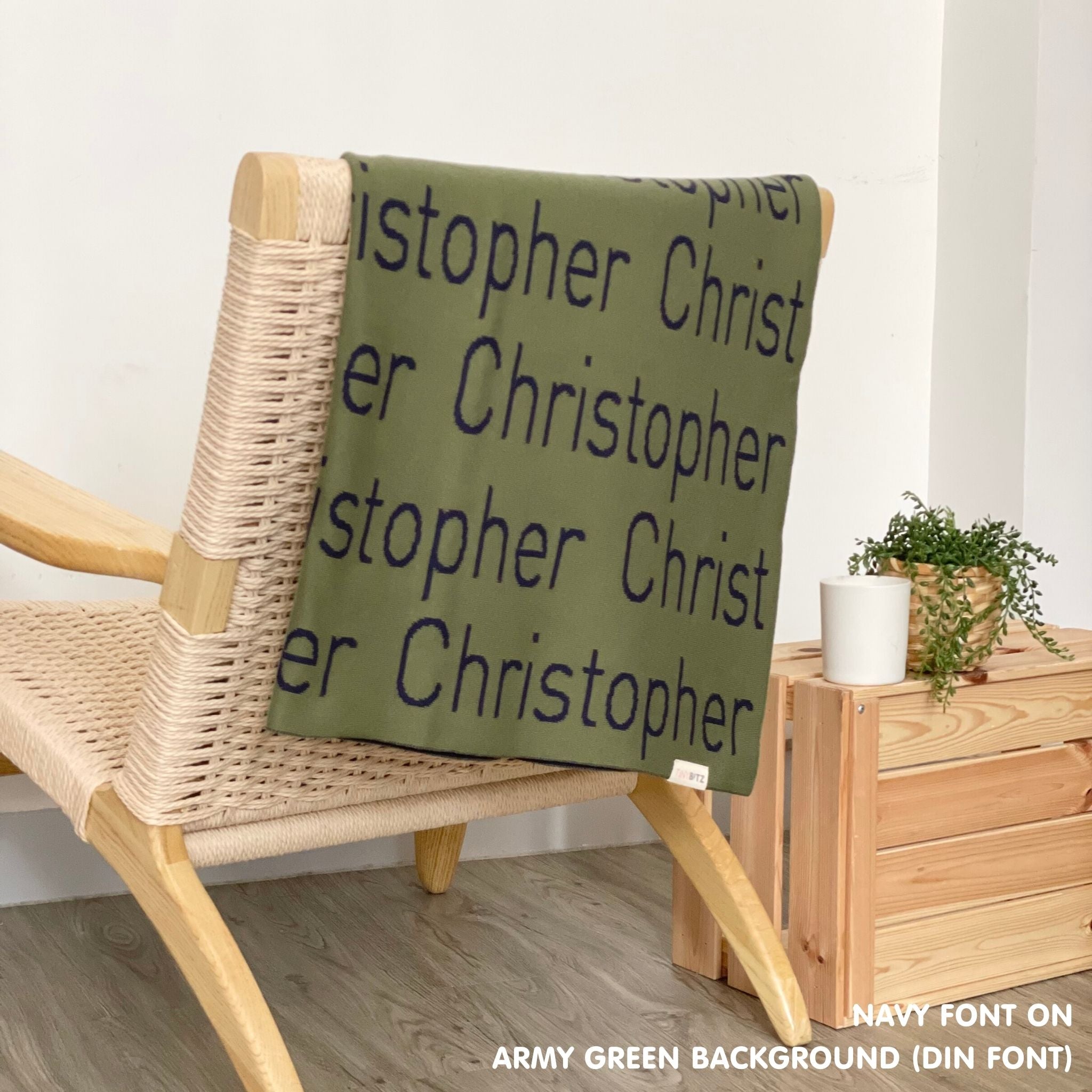 Customisable blanket with adult's name knitted in army green and navy, personalized by TinyBitz.