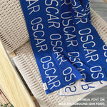 TinyBitz knitted baby boys blanket in blue background and oatmeal, personalized with your baby’s name.