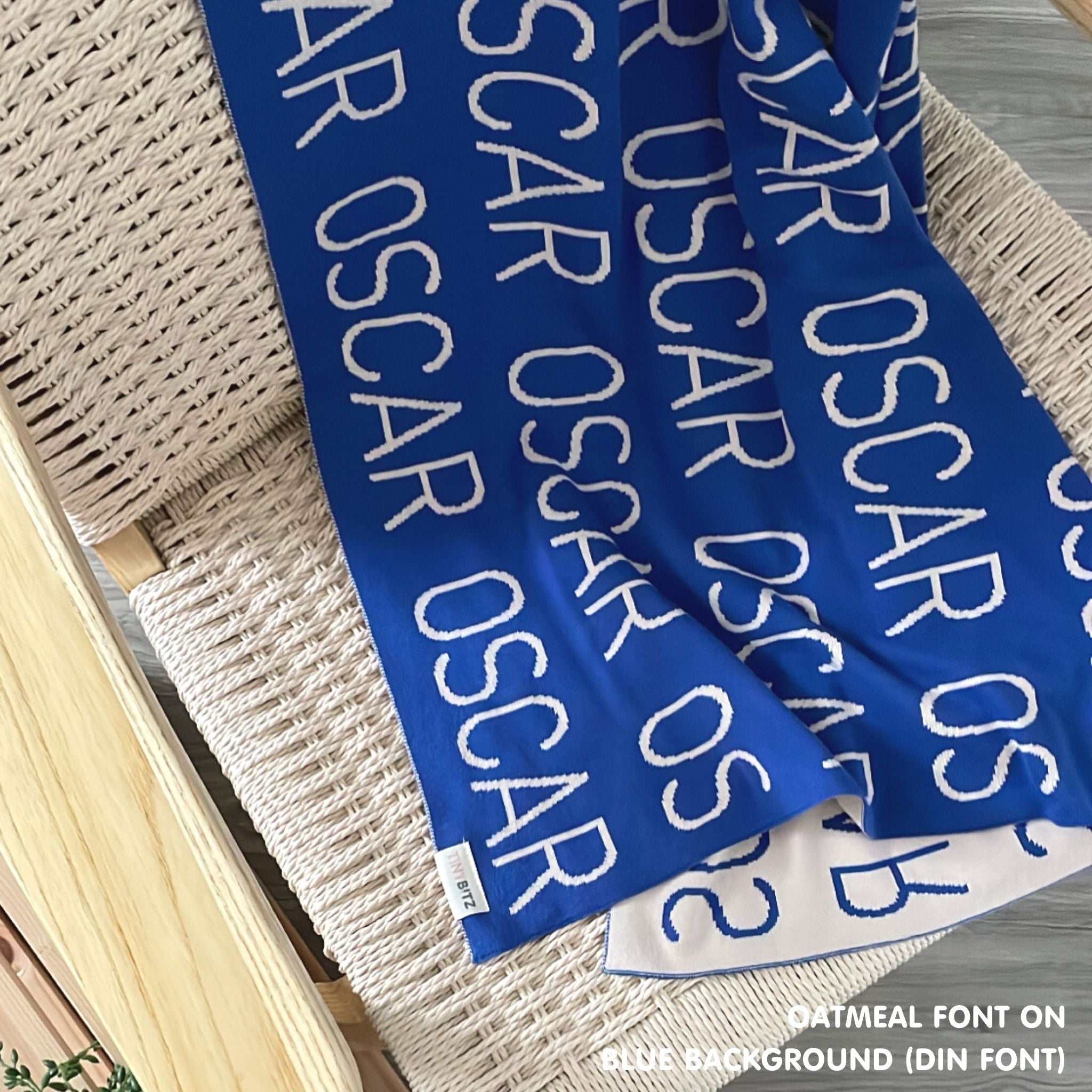 TinyBitz knitted baby boys blanket in blue background and oatmeal, personalized with your baby’s name.