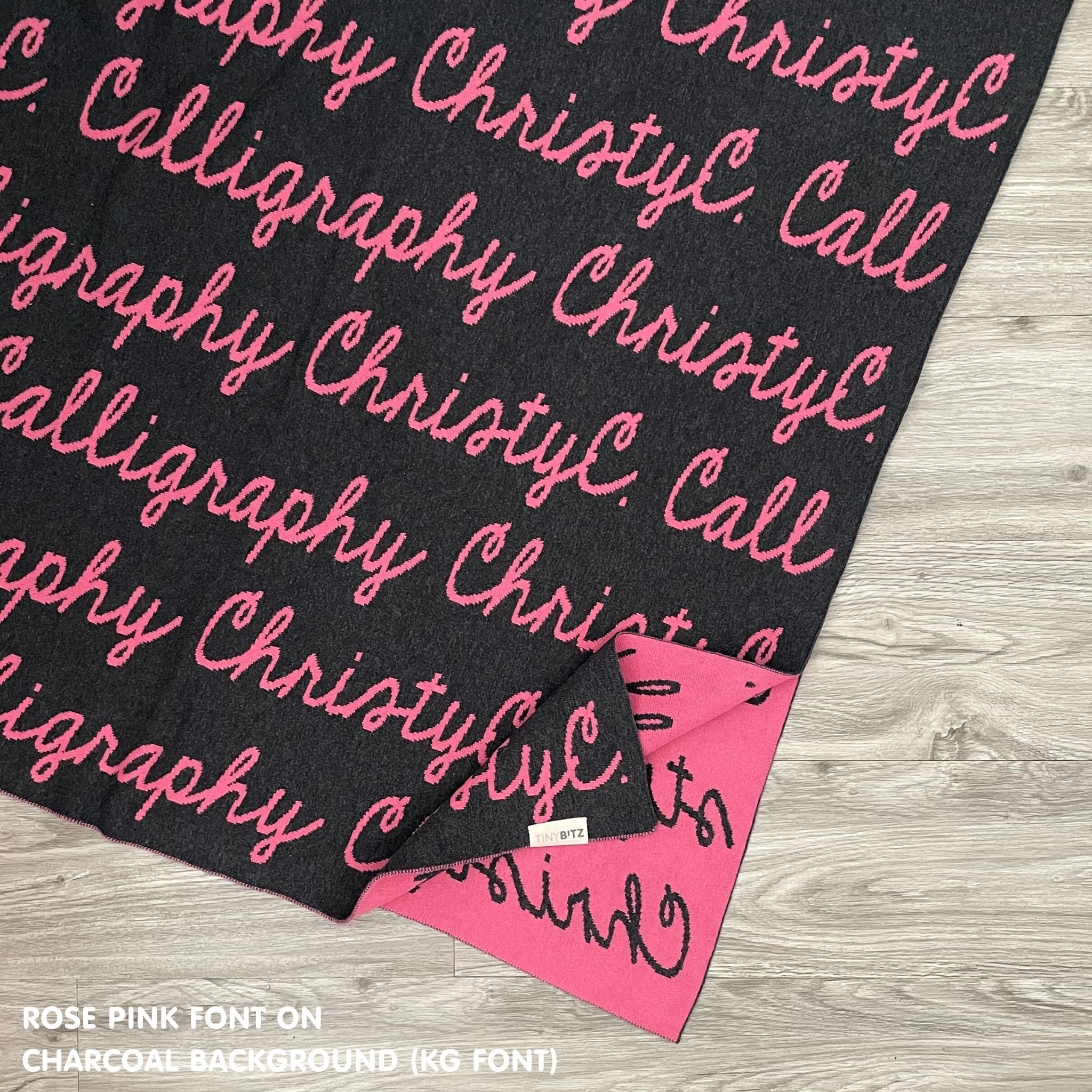 Knitted baby blanket in charcoal and rose pink, customised with baby's name, made by TinyBitz.