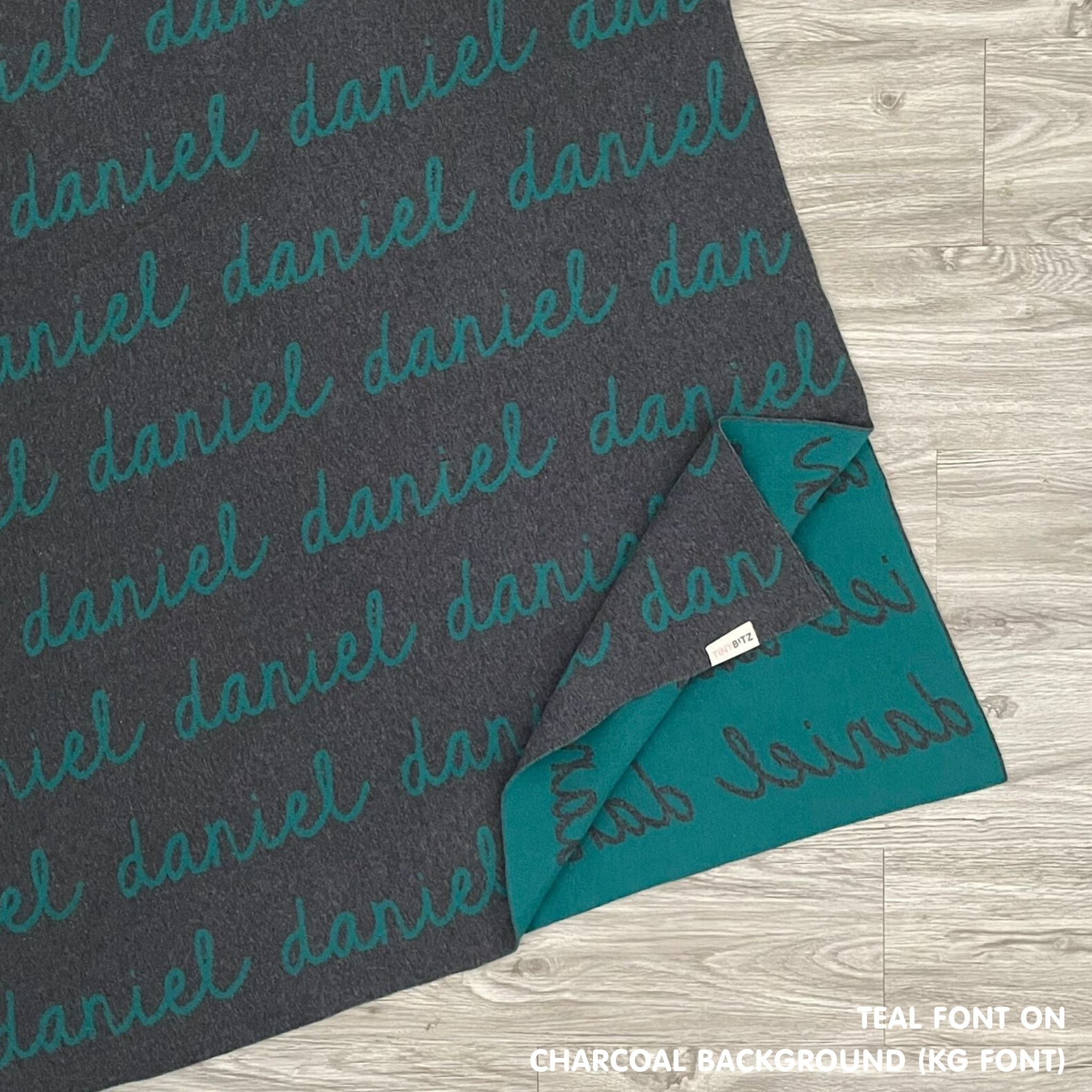 Baby blanket knitted from cotton personalized with baby's name in charcoal and teal, made by TinyBitz.