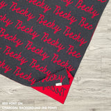 Personalised pet blanket in charcoal and red knitted cotton, custom dog blanket by TinyBitz, styled on modern wooden dog bed.