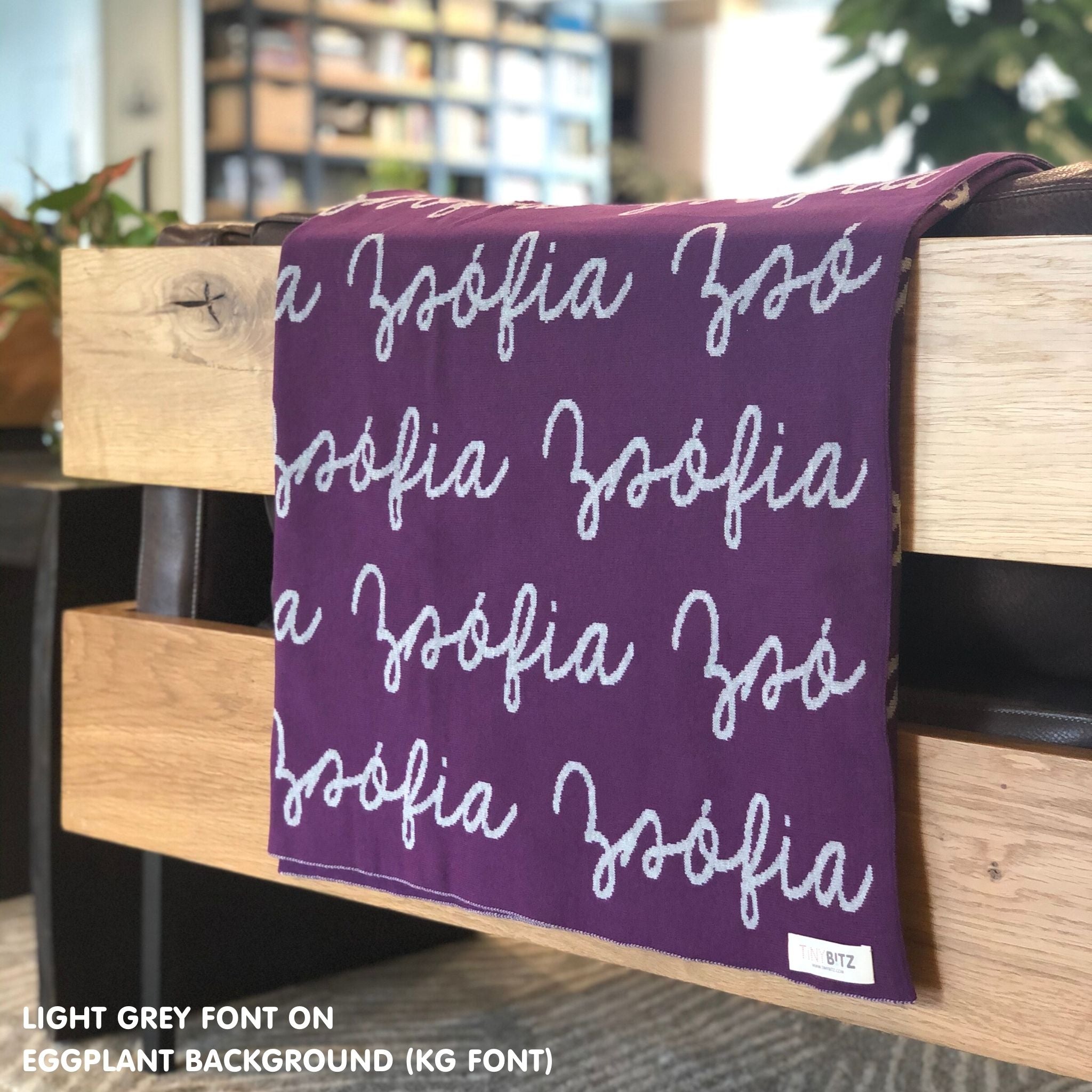Customisable blanket with adult's name knitted in eggplant and light grey, personalized by TinyBitz.